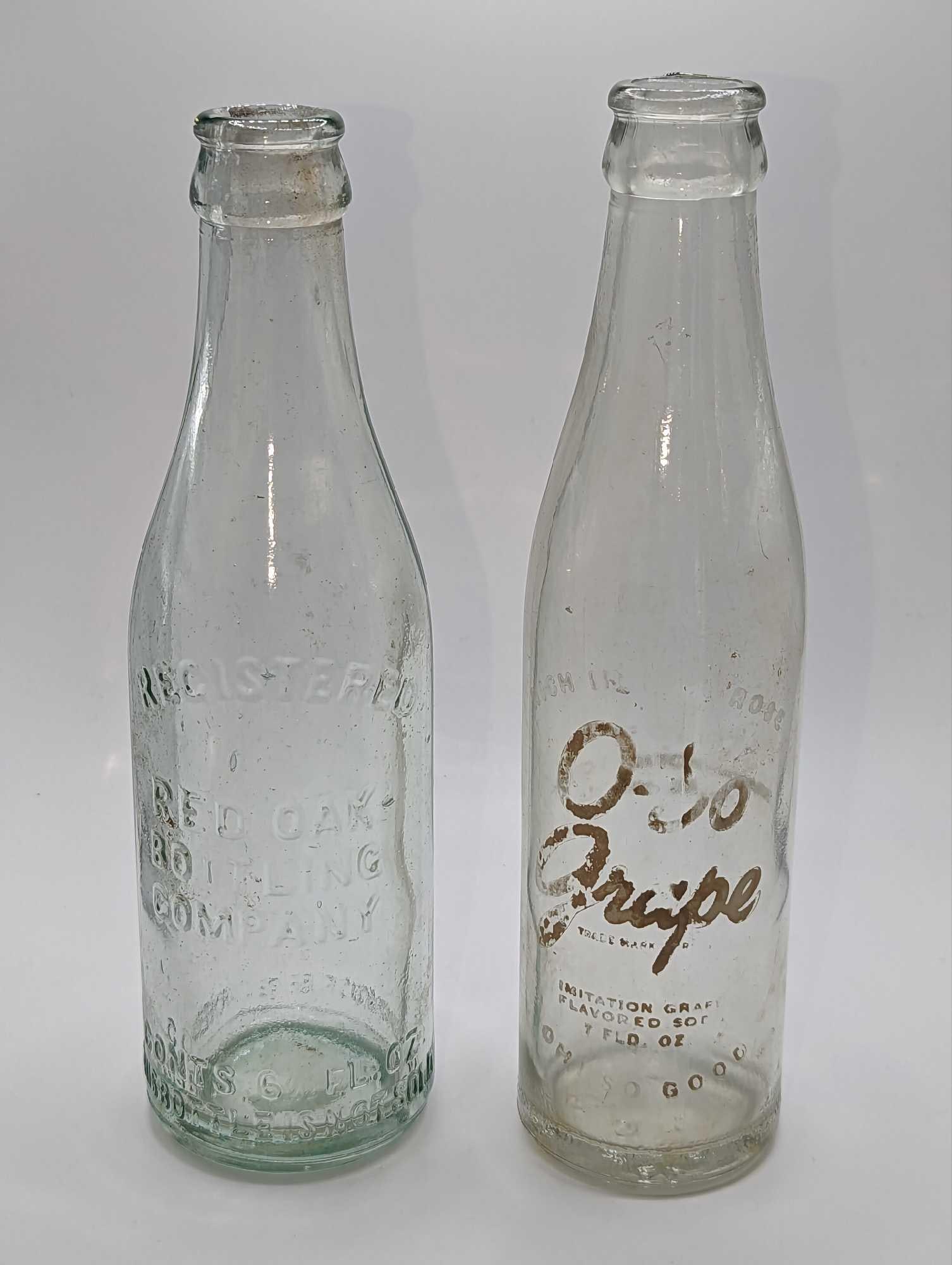 2 Vintage O-So Grape Red Oak Bottling Company Glass Bottles: 2 Vintage O-So Grape Red Oak Bottling Company Glass Bottles. This lot includes: (1) Vintage O-So Grape Soda Bottle. This is from the Suburban Club Bottling Company From The Lynchburg, Virginia. 