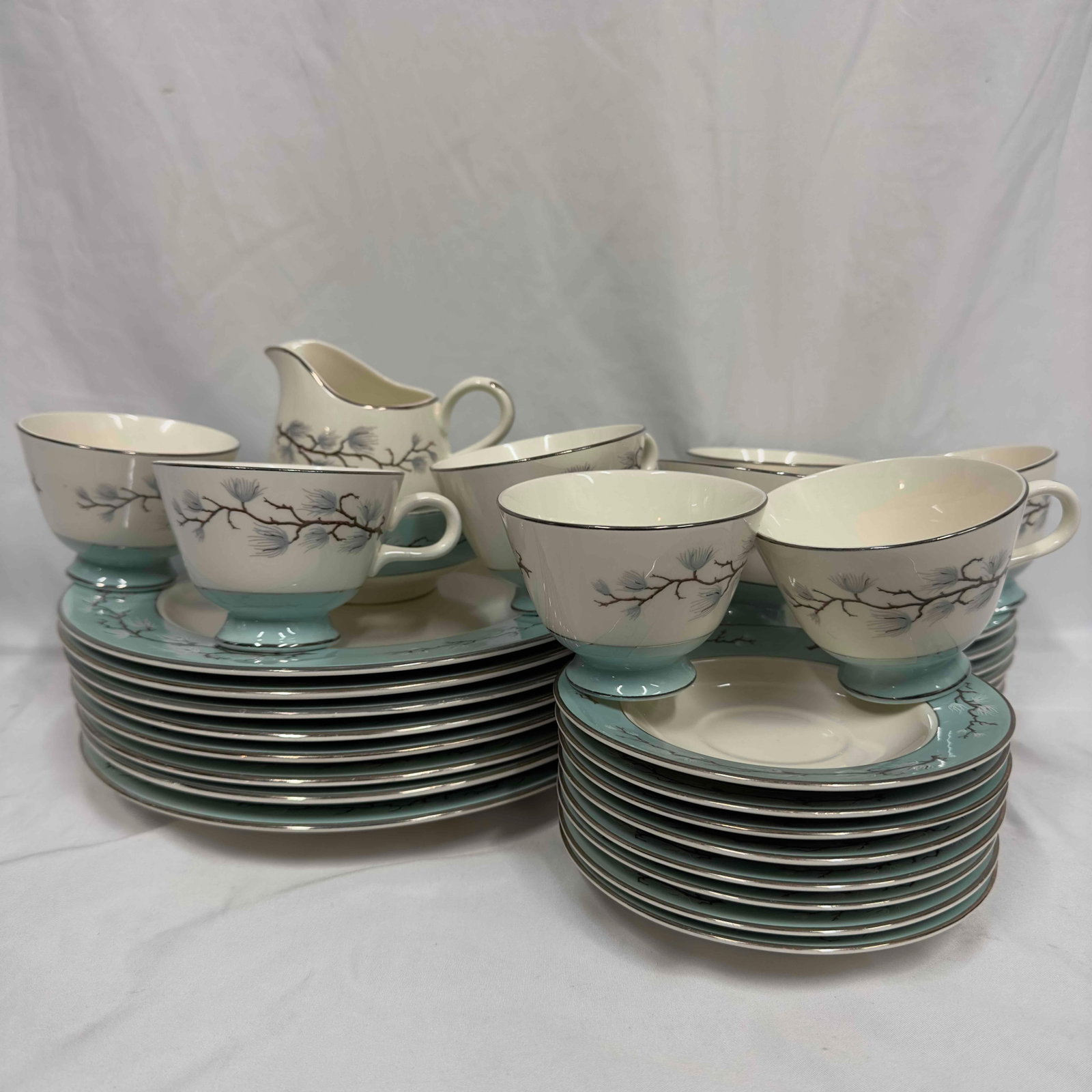 Vintage Cavalier Eggshell Homer Laughlin Turquoise Line Leaves Romance 33 Piece Set: The lot features a 33 piece set Romance Pattern by Homer Laughlin. Manufactured by Cavalier U.S.A. The floral design surrounded by leaves enhances the turquoise trim and silver trim. This set