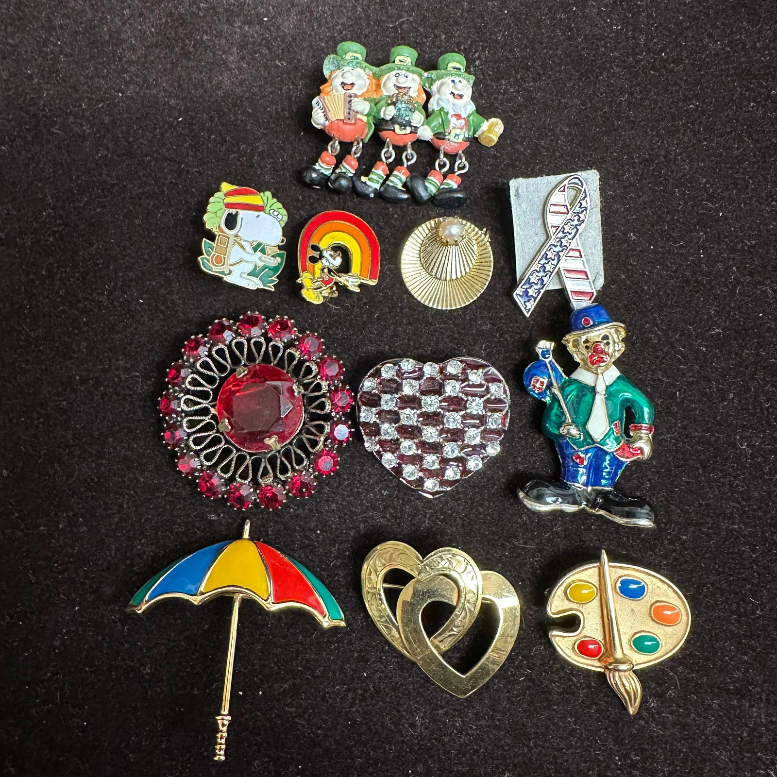 Group Lot of Costume Brooches and Pins Floral Novelty Holiday and Rhinestone Designs R83: Mixed lot of assorted costume jewelry, brooches, and pins. Includes floral motifs with faux pearls and enamel, novelty designs (clown, leprechauns, Snoopy, rainbow, umbrella, artist palette), patrioti