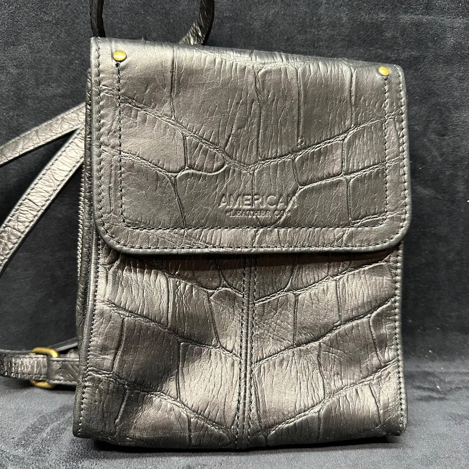 American Leather Co. Black Leather Faux Crocodile Embossed Crossbody Bag: Pre-owned condition with light surface wear consistent with normal use. Includes original dust bag. Please reference all photos for full condition details. Bag: 7 3/4" x 6 3/4" x 2''.