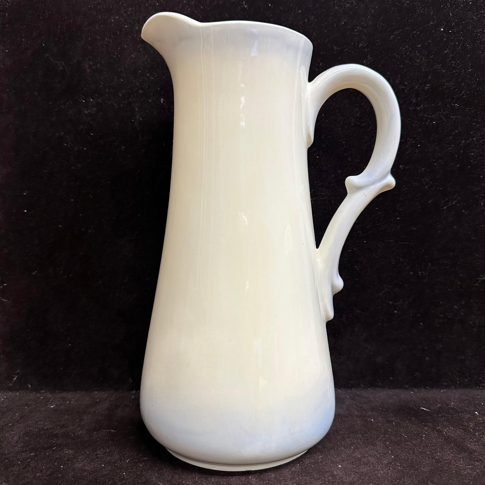 Vintage White Glazed Blue Hue Accent Ceramic Pitcher Handle Marked G.B. 1988: Vintage ceramic pitcher featuring a tall, tapered form with a gently flared spout and applied loop handle with thumb rest detail. Finished in a glossy white glaze with a blue hue accent. Underside