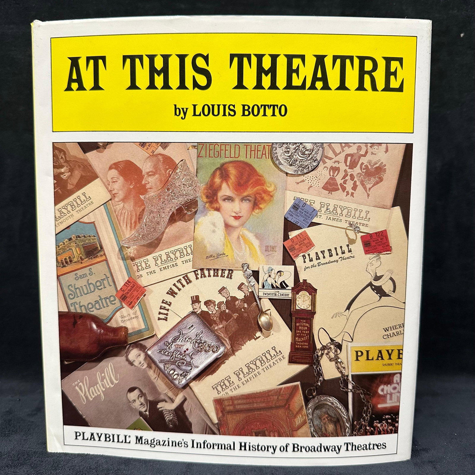At This Theatre by Louis Botto Hardcover 1984 Playbill Magazines Broadway Theatres Signed: Signed by Louis Botto with a personal inscription to Michel Roux. Includes original dust jacket. Condition shows general handling wear, scuffing, and surface marks to the cover and jacket consistent