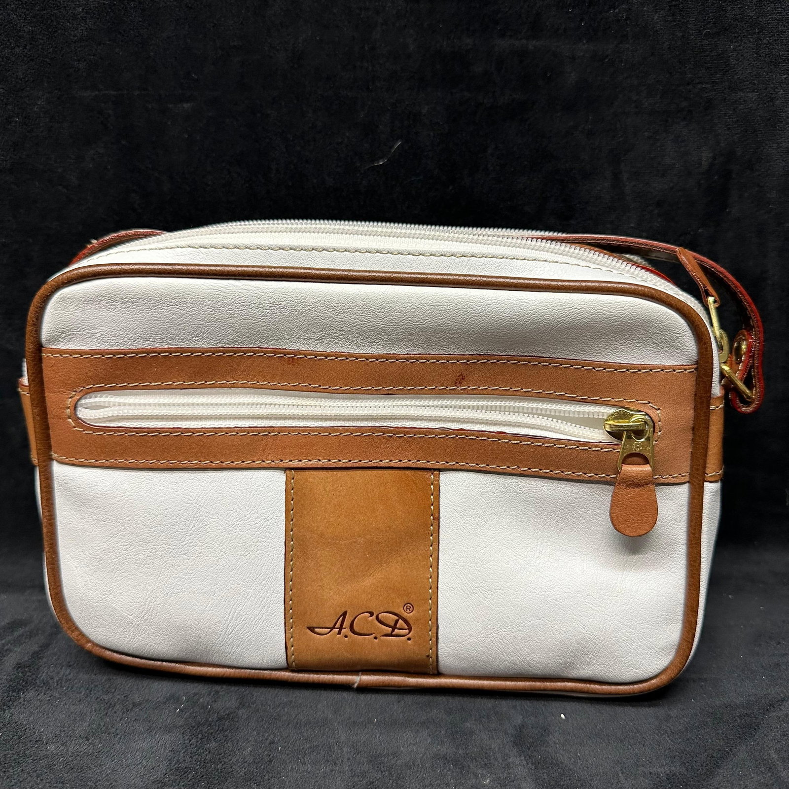 A.C.D. Marked White and Tan Leather Crossbody Shoulder Bag: A contemporary A.C.D. marked leather handbag featuring a structured rectangular form in white leather with tan leather trim and accents. The bag is designed with a top zip closure and an exterior zip