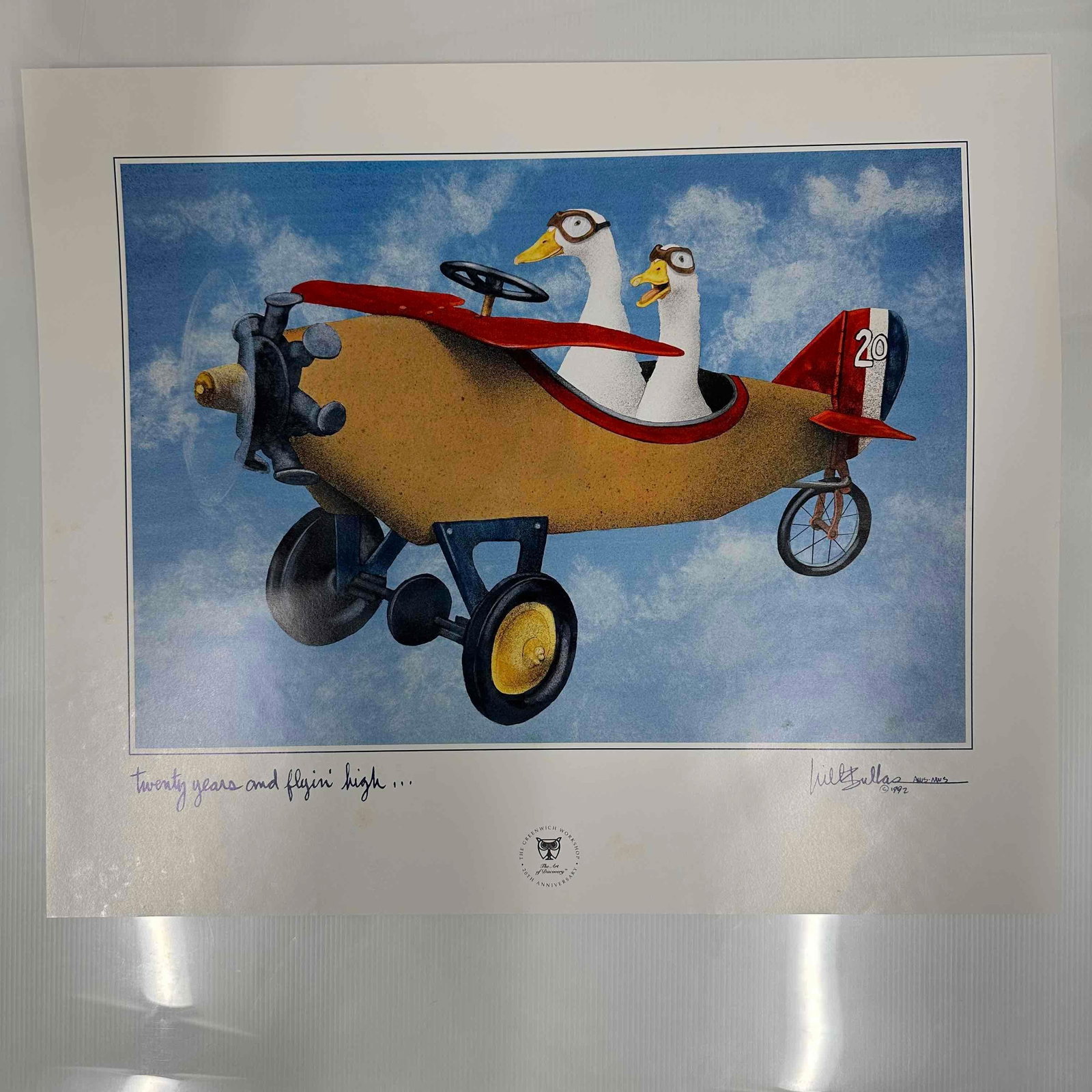 1992 Will Bullas Signed Limited Edition Print Twenty Years and Flyin’ High Greenwich Workshop: 1992 limited edition print by renowned artist Will Bullas, titled “Twenty Years and Flyin’ High”. Features two ducks flying in a whimsical airplane against a bright sky, celebrating 