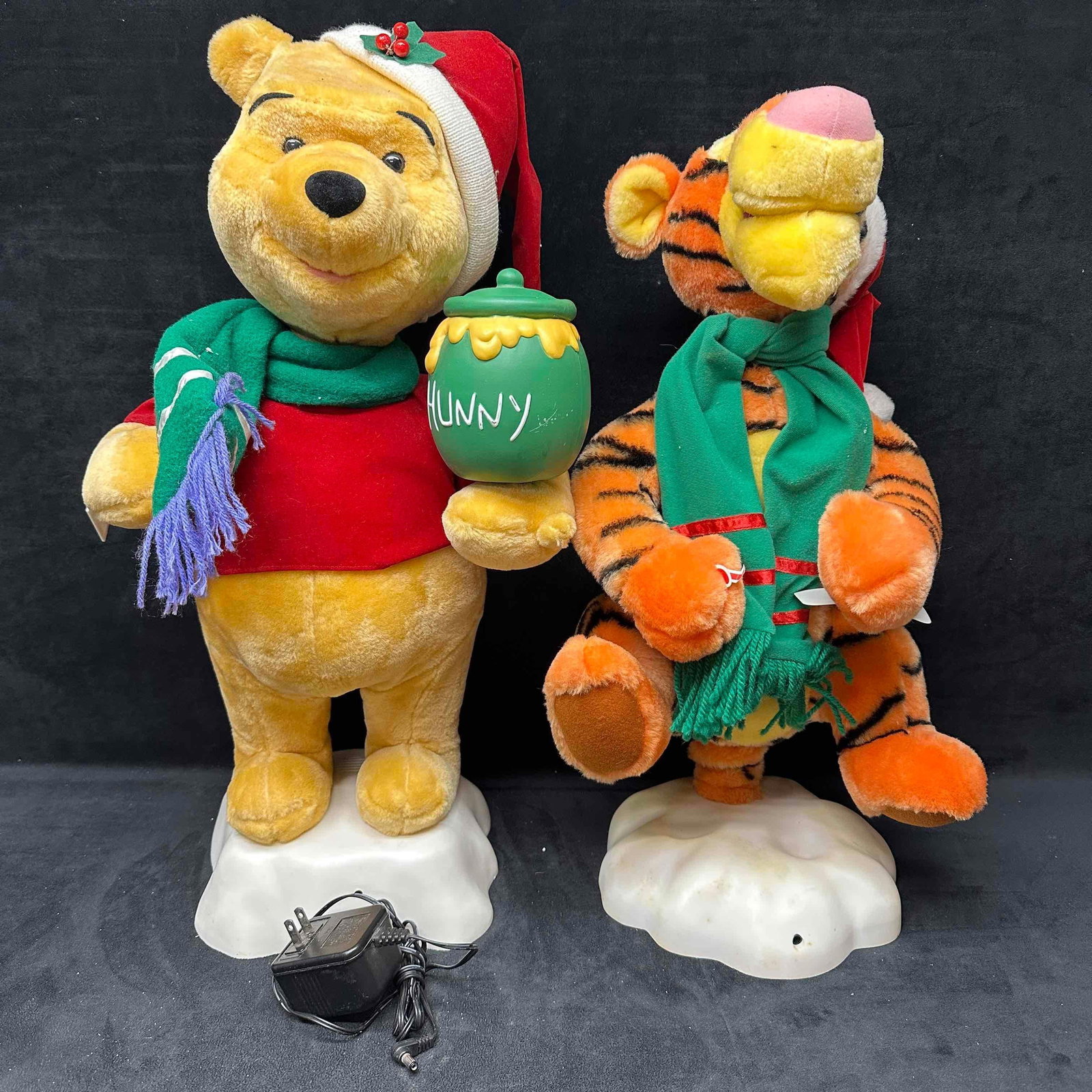 Winnie the Pooh and Tigger Animated Musical Holiday Decor: This holiday Disney decoration set features Winnie the Pooh and Tigger, both showing light debris and markings throughout the decor pieces. Tested. The Pooh figure is working well but the Tigger 