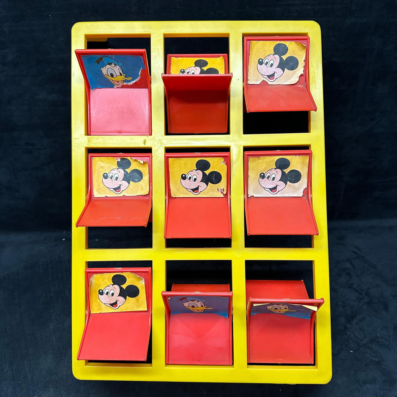 Disney Mickey Mouse Pitch N Pop Vintage Arcade Style Toy Game: Vintage plastic Mickey Mouse Pitch N Pop tabletop game featuring pop-up character targets, including Mickey and Donald. Yellow base with red flip-tabs. Shows age-related wear, fading, and missing/loos
