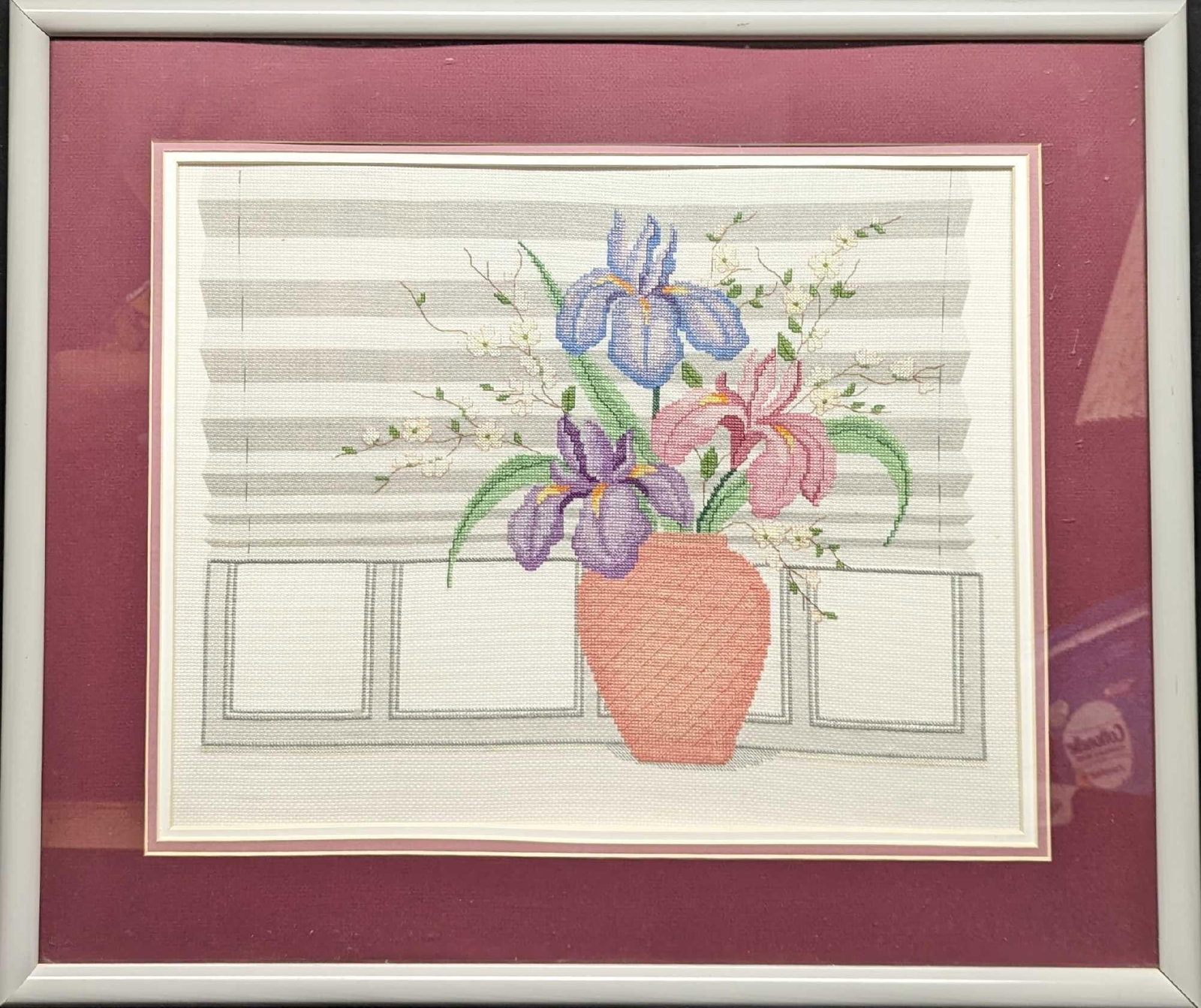 Framed Cross Stitch Embroidery Iris Flowers In Pot: Framed Cross Stitch Embroidery Iris Flowers In Pot. This is approx 25 1/4" x 1" x 21" and it weighs 8lbs. There are some smudges/markings on the plex and there is some buckling on the bottom. The