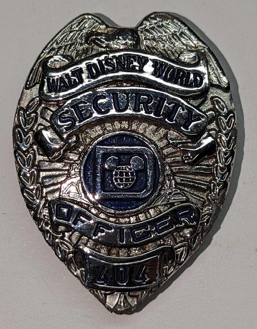 Early 1980s Disney World Female Security Badge 404: Early 1980s Disney World Female Security Badge 404. Is approx 1 3/4" x 1/4" x 2 3/8" and it weighs under one pound at 0.10lb. The metal badge is in a good, vintage condition with some scratches a