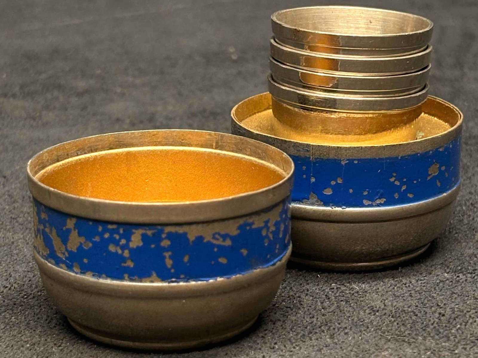 Mid Century 5pc Metal Silver and Blue Portable Nesting Shot Cups: Consisting of 4 shot cups and compact storage, this lot is mid-century and travel-size. These individual shot cups is suspected to be a durable chrome-plated metal, originally presented in but no long