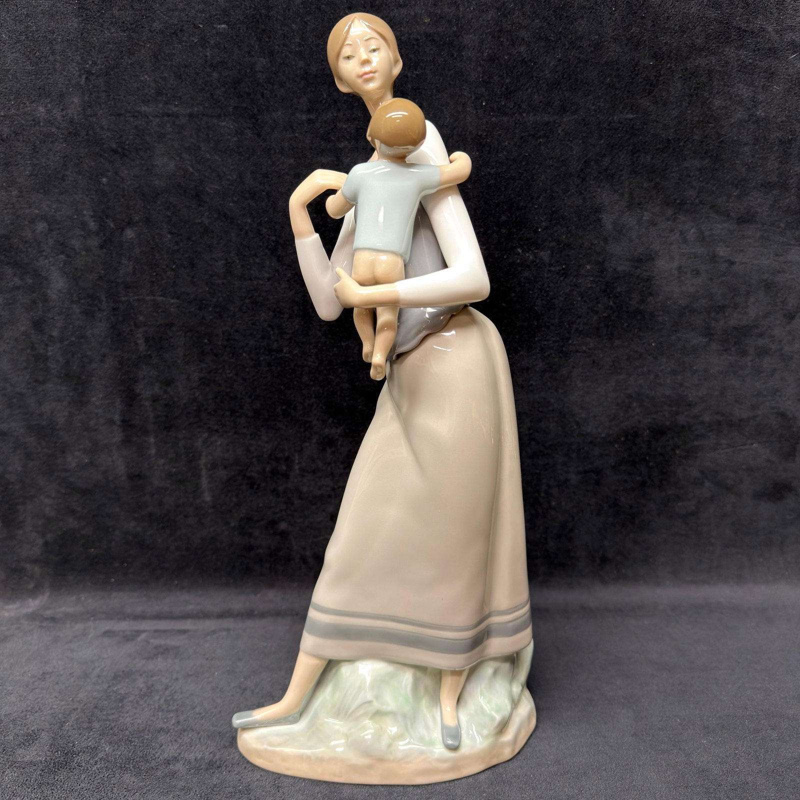 Lladro 4701 Mothers Love Mother and Child Porcelain Figurine R240: Lladro porcelain figurine, model 4701, titled Mother's Love. This elegant sculpture depicts a mother carrying her young child in Lladro's classic pastel color palette. Marked