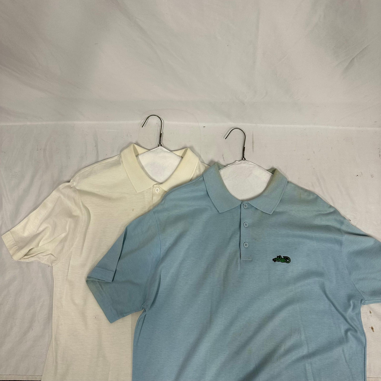 Two 2 Anvil Brand Short Sleeve Polo Shirts Size Large Blue and Off White: A lot of two Anvil Brand short sleeve polo shirts, both size Large. Includes one light blue polo with embroidered crocodile motif at the chest and one off-white polo with embroidered horse-and-rider s