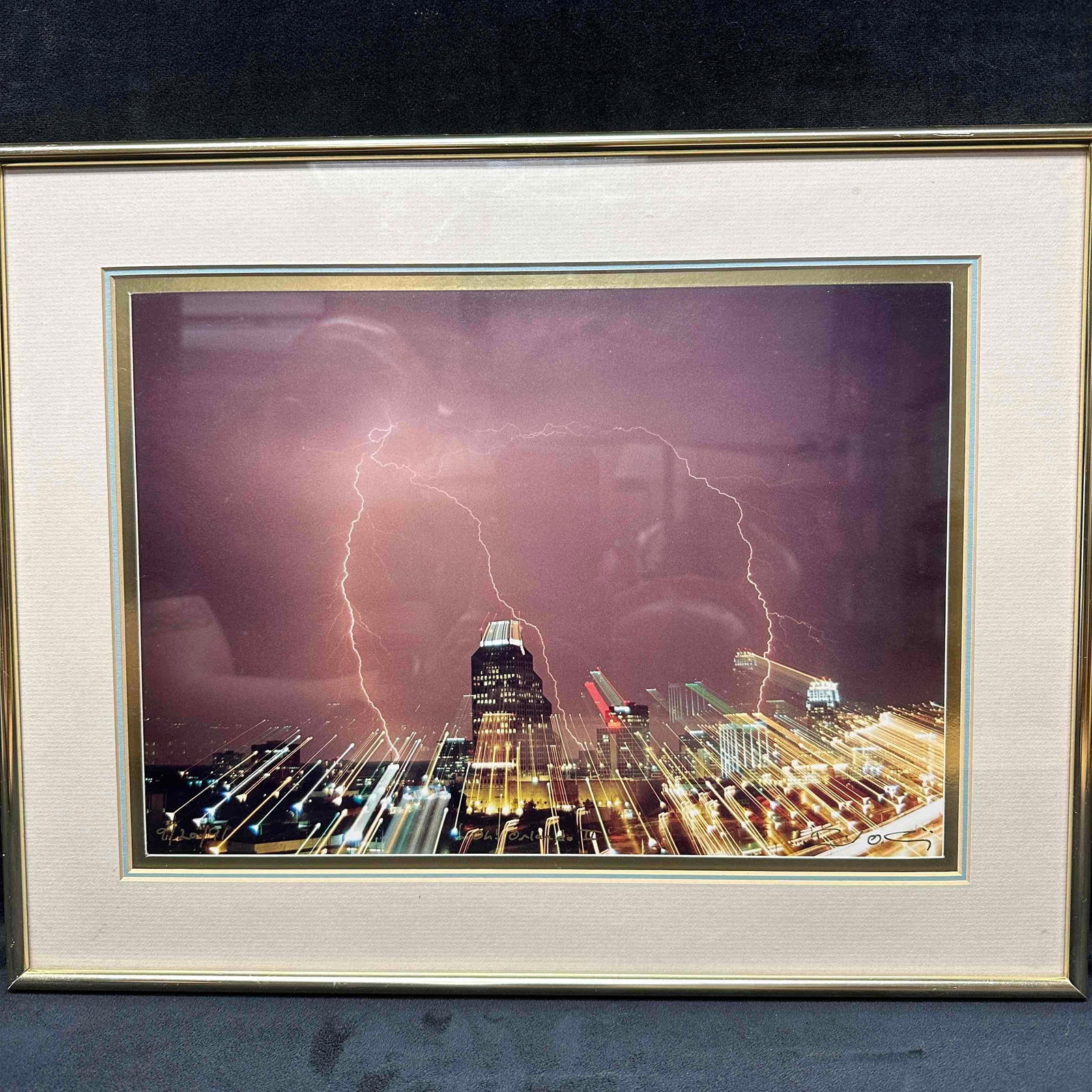 Oh! Orlando II 1991 Electric Storm Over the City Framed Photography: Striking long-exposure photograph capturing a vivid lightning storm over a vibrant city scape at night. The dramatic light trails and electric bolts create a sense of motion and energy. Signed by the 