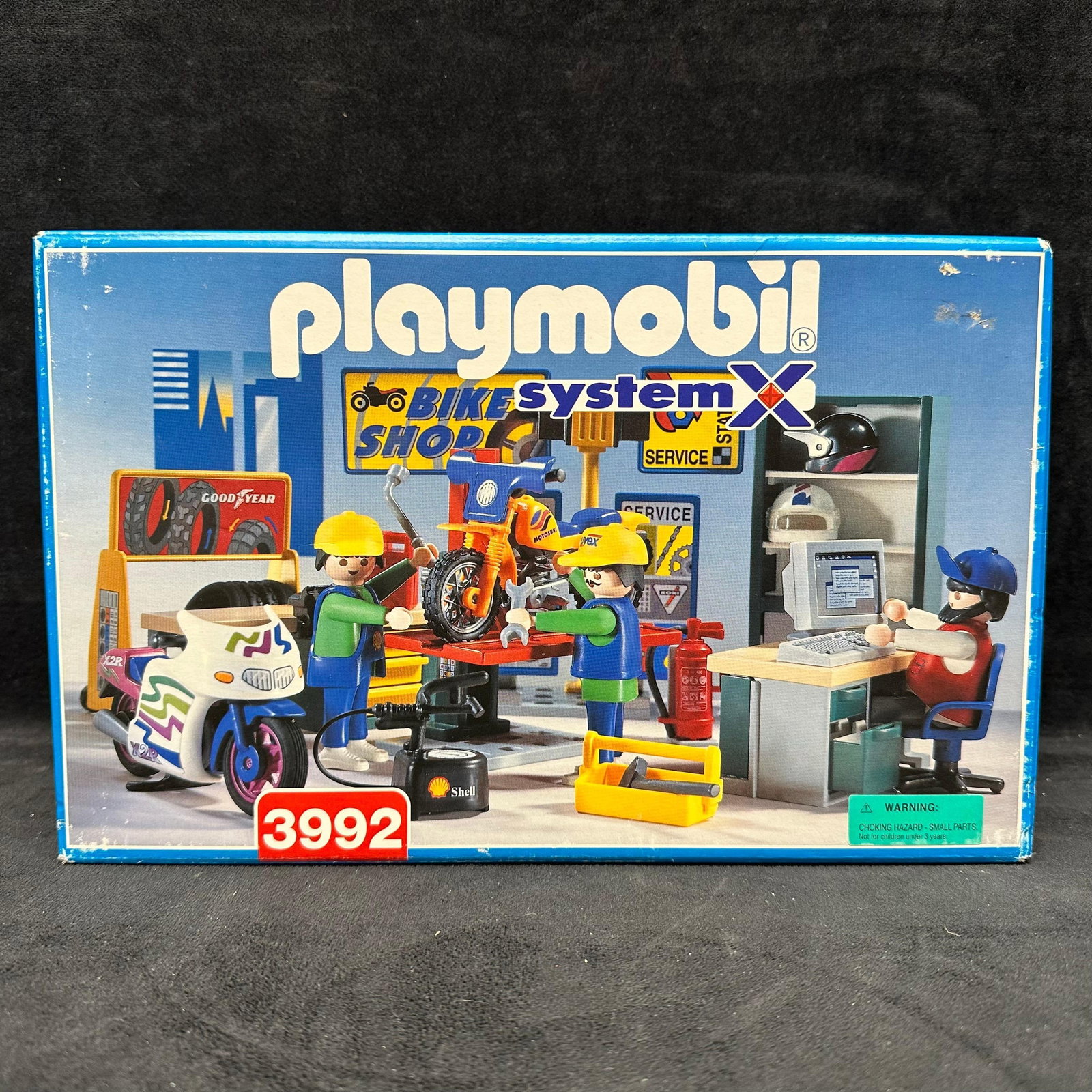 Playmobil System X Bike Shop Set No. 3992: Playmobil System X Bike Shop set in original box. Includes figures, motorcycles, tools, accessories, and shop components as shown. This item is in like-new, never opened, previously displayed conditio