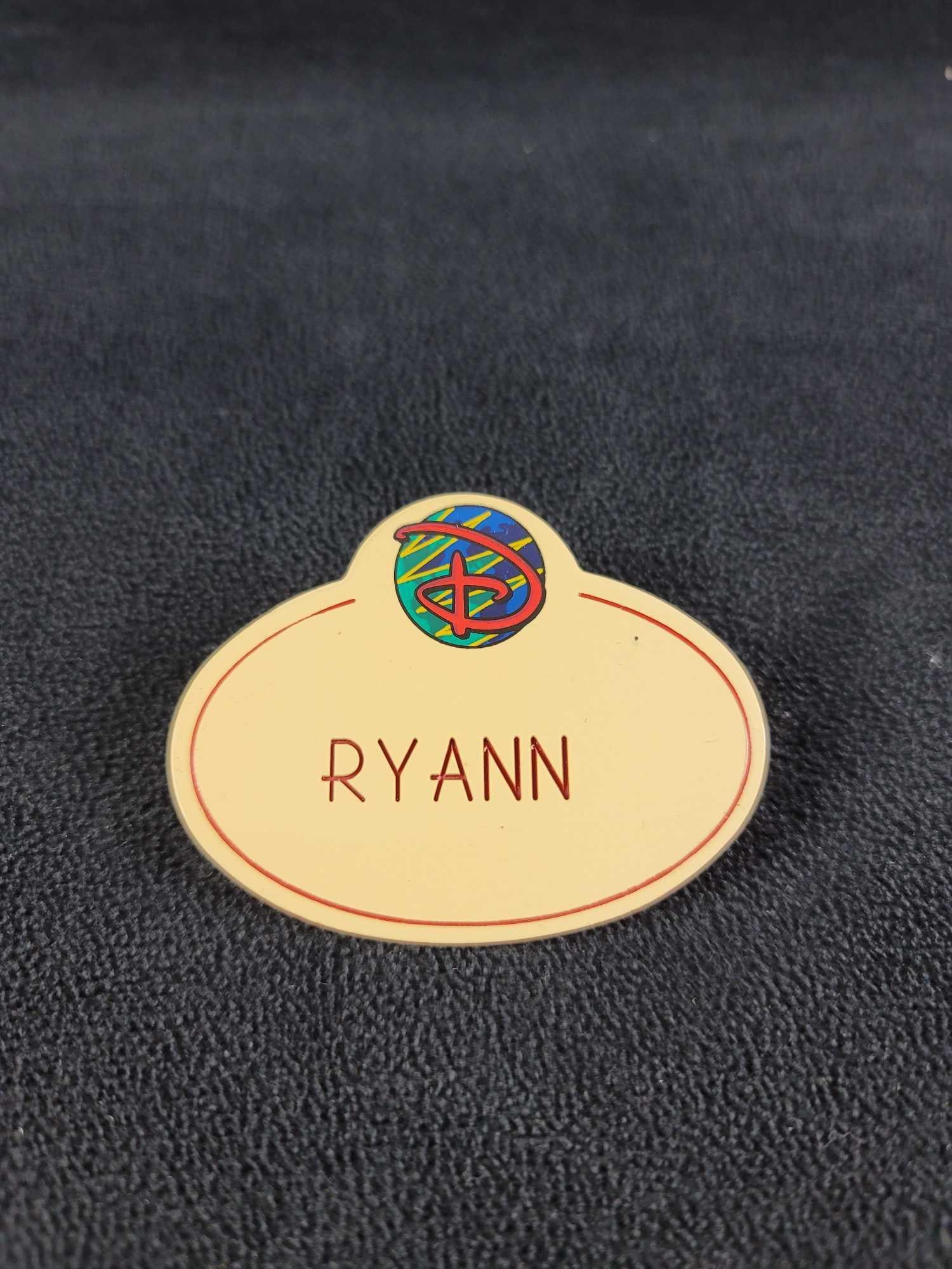 Disney Cast Member Name Badge RYANN: This name badge is in good condition with some known ware and discoloration. Stamped on the back Disney 98. The name on the front is Ryann. Approx. measures 2 1/2" x 2", weight is .01 lbs