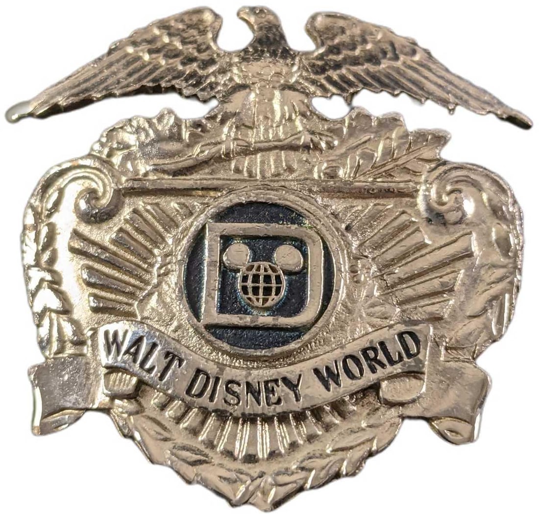 1970s/1980s Walt Disney World Security Hat Badge: This badge adorned the hat of the Walt Disney World Park Security Employees during the 1970's/1980s. The back of the badge has two threaded prongs that fit through two holes in the hat and were