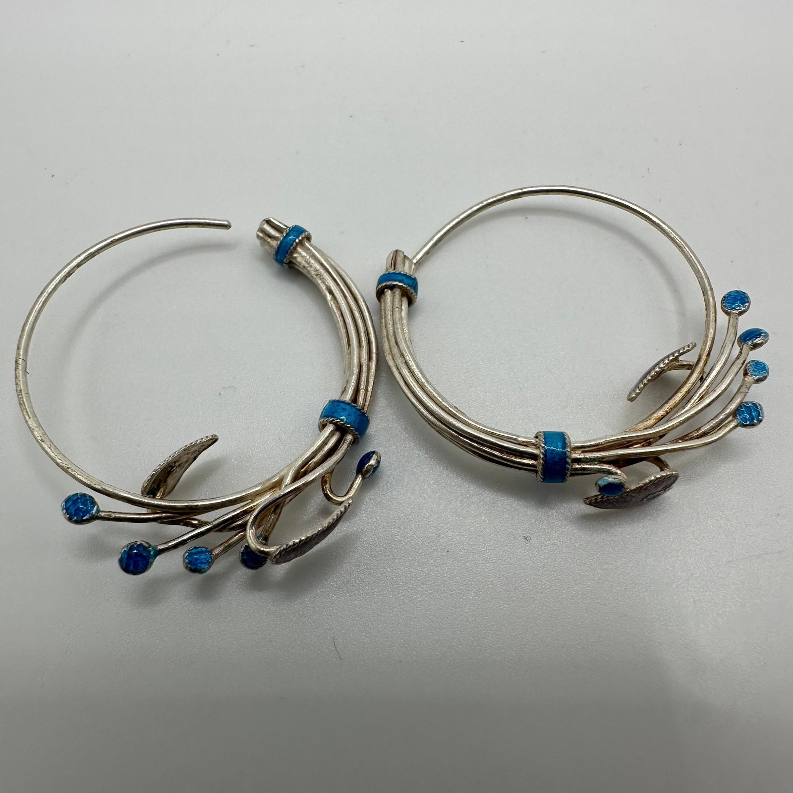 Floral Abstract Design Blue and Purple Enamel Sterling Hoop Earrings: This item is in good pre-owned, previously used/displayed condition with noticeable light wear and surface scratches. Please reference all photos for full details. This piece of jewelry has been teste