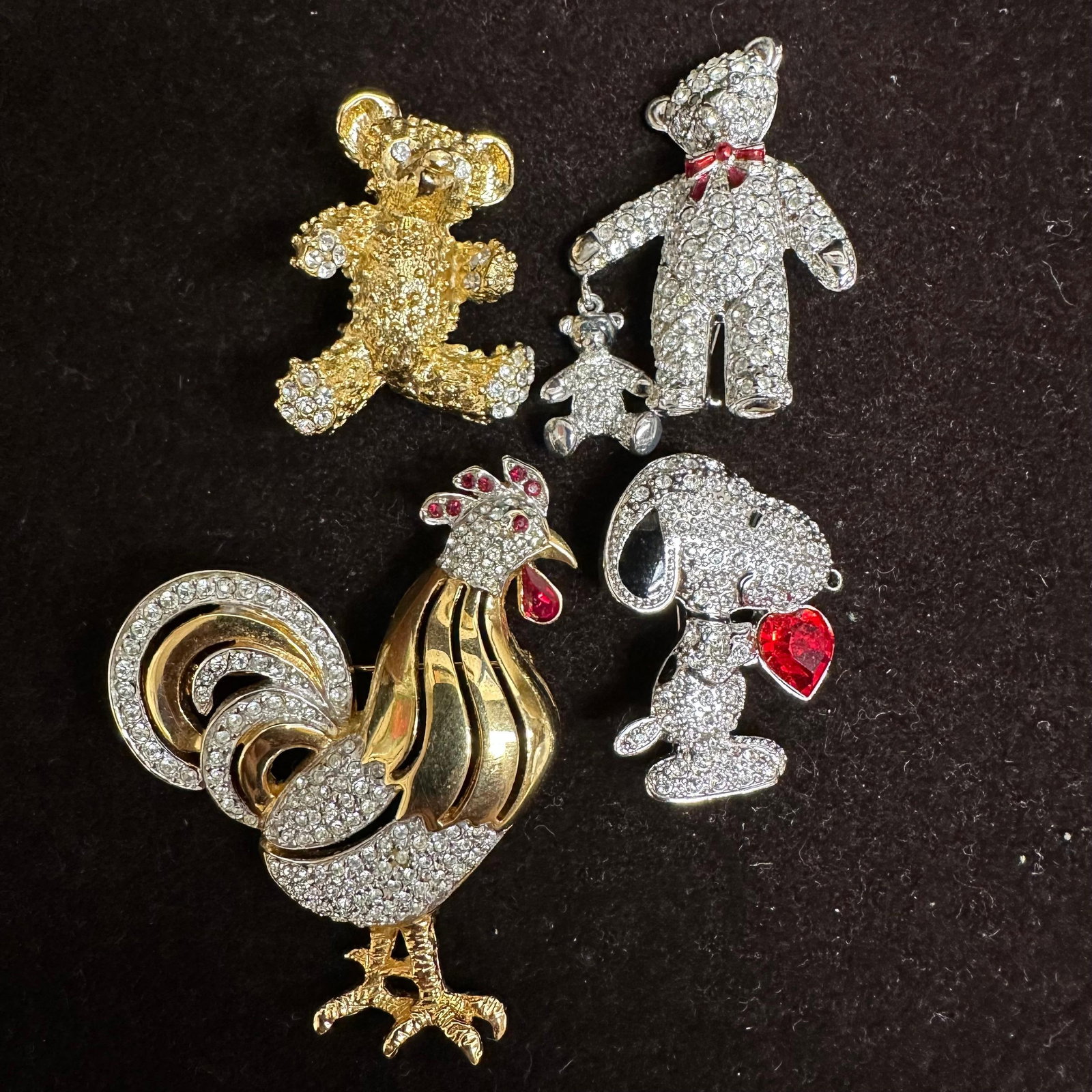 Group of Rhinestone Costume Jewelry Brooches Teddy Bears Snoopy Rooster: Group of decorative costume jewelry brooches featuring animal and character motifs. Includes multiple teddy bear designs, Snoopy with red heart accent, and a rooster brooch. Pieces are set with clear 