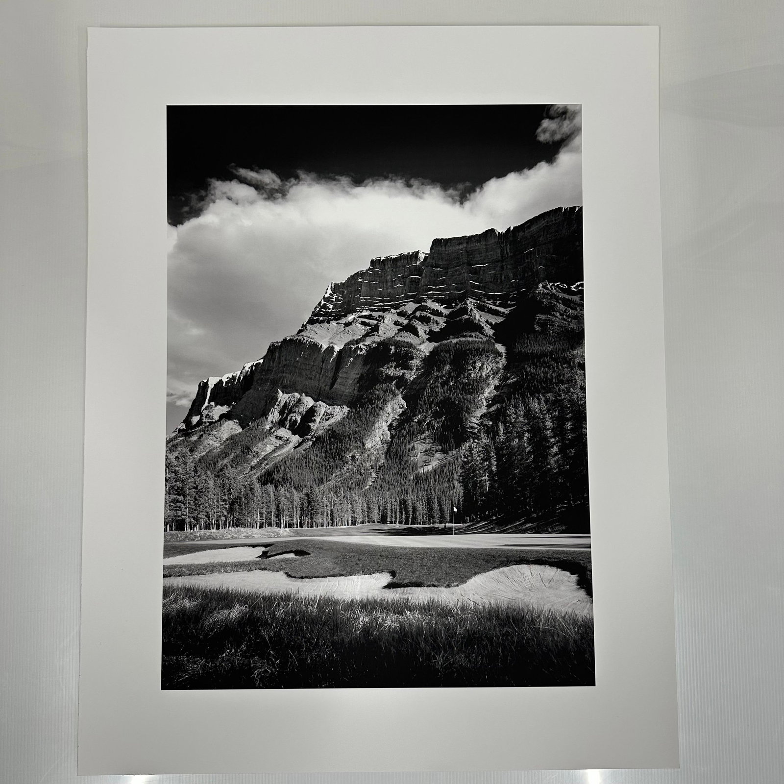 Black and White Landscape Photograph Print Mountain and Golf Course Scene Large Format C: Large format black and white photography print showing a dramatic mountain range rising above a golf course. The image features strong contrast, detailed texture, and balanced composition. Printed on 