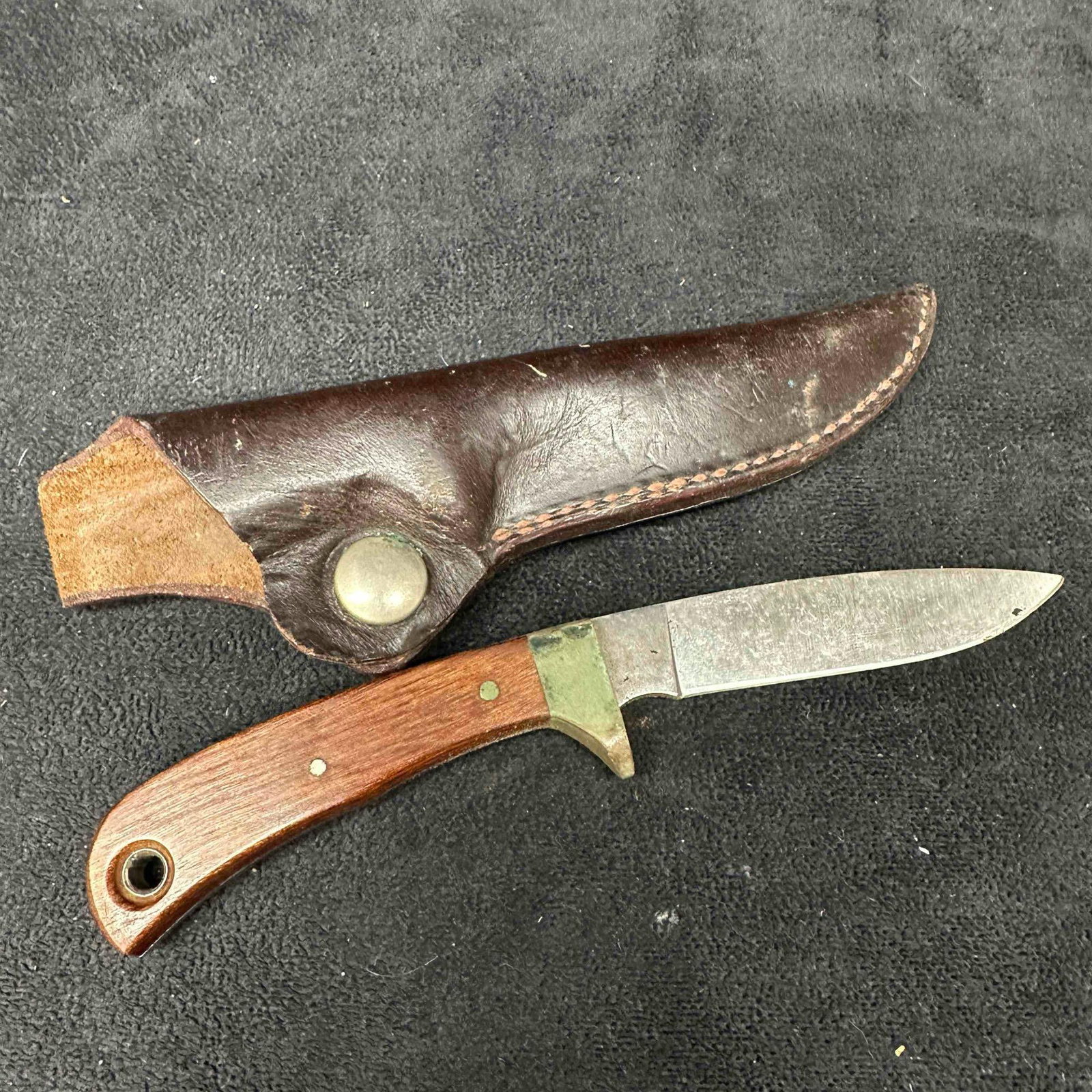 Bowen Fixed Blade Stainless Steel Hunter Knife with Sheath: Light discoloring green coloration on metal, light patina. Includes dark brown leather sheath. This item is in good pre-owned, previously used condition with light wear, and surface scratches. Please