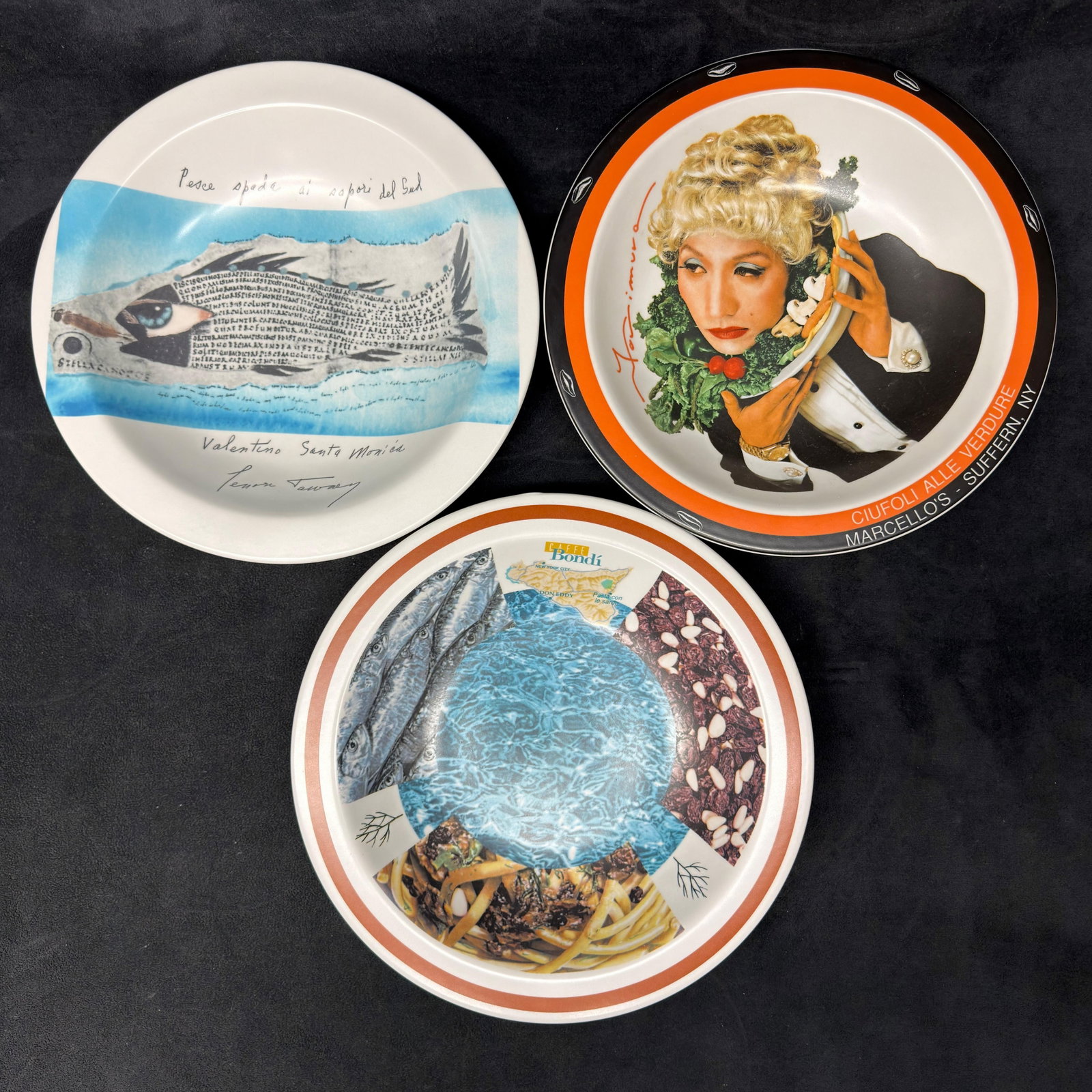 Three Buon Ricordo America Limited Edition Artist Plates Made in Italy: Collection of three Buon Ricordo America limited-edition decorative restaurant plates, including designs for Picci Spada al Sapori del Sud by Florence Tanney, Ciufoli alle Verdure for