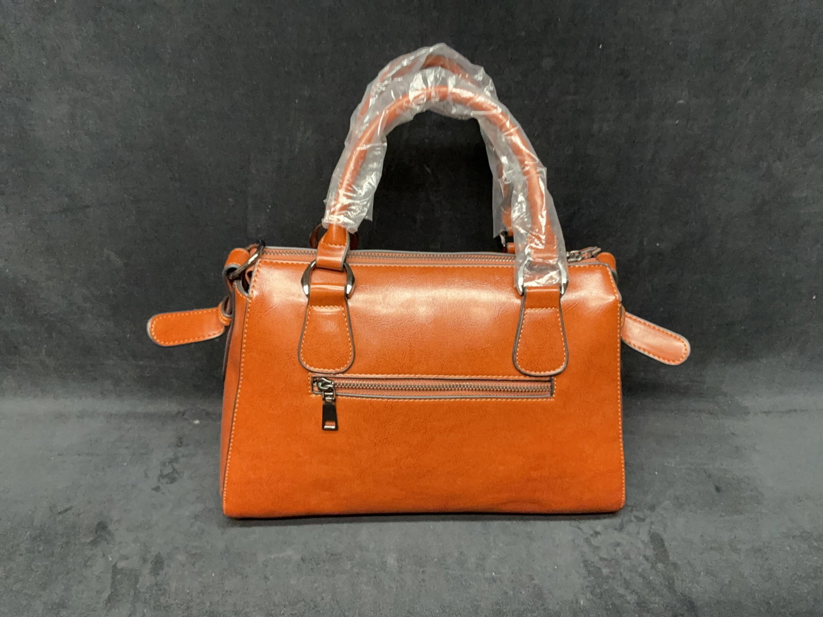Faux Natural Leather Handbag With Crossbody Strap: Faux Natural Leather Handbag With Crossbody Strap Brown leather style bag with black trim. Comes with shoulder strap to be worn cross-body. In new condition. Approximate weight: 2
