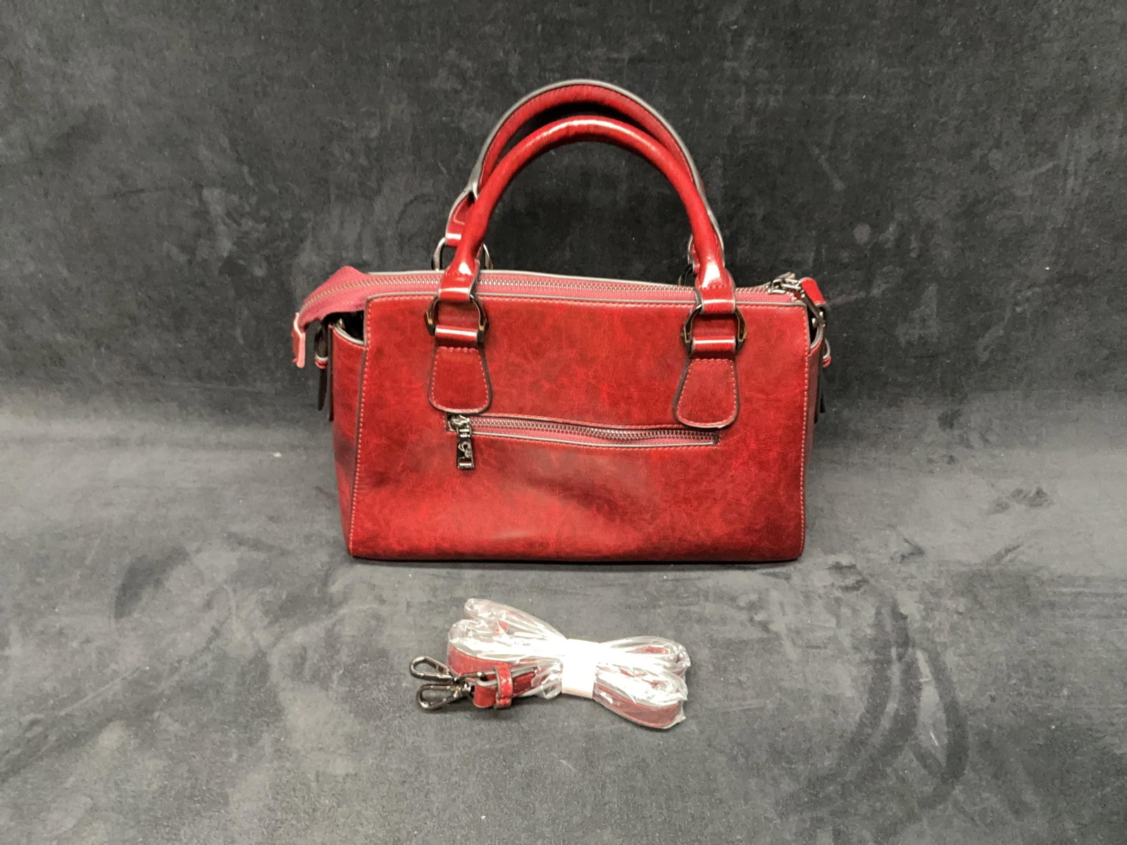 Burgundy Satchel Handbag With Shoulder Strap: Burgundy leather-style satchel handbag with top handles, zippered accents, and detachable shoulder strap. Please see photos for best description of condition. Approximate Size: 13 x 14 x
