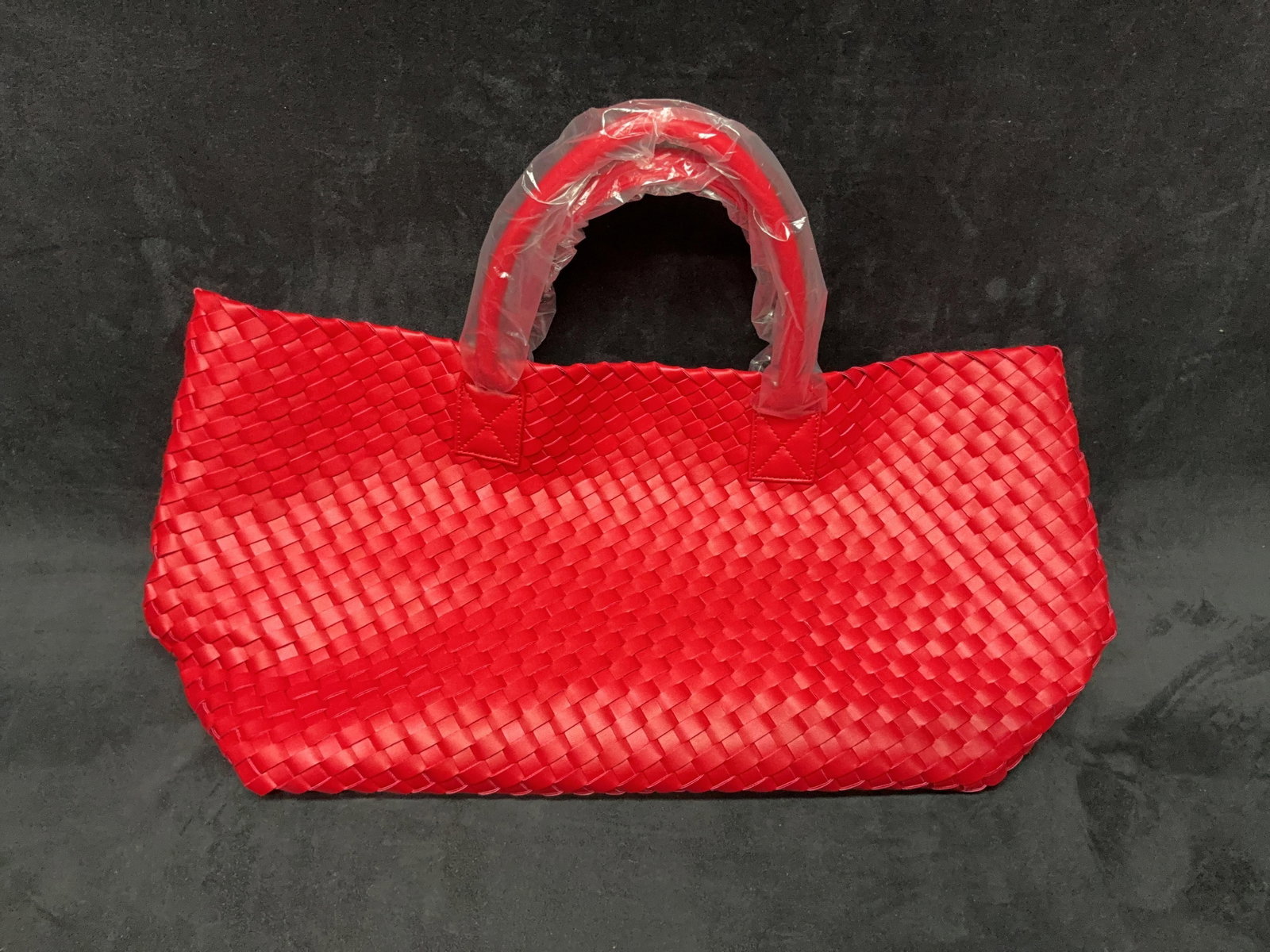 Red Woven Leather-Style Tote With Wallet: Red woven leather-style tote bag with dual handles and included wallet. Appears unused with protective wrapping present on handles. Please see photos for best description of condition.