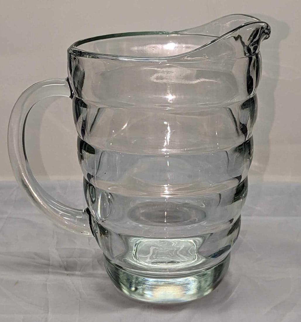 Vintage Deco Ringed Glass Pitcher: Vintage Deco Ringed Glass Pitcher. Its maker and date of creation are unknown. The glass pitcher is approx 7 3/4" x 5" x 8" and it weighs 3.70 lbs. The glass pitcher has light scratches. 