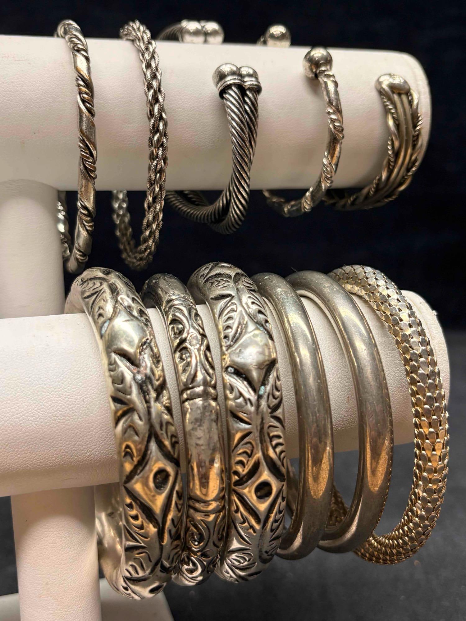 11pc Silver Tone Celestine Argent Costume Jewelry Bracelet Collection: This lot contains 11 pieces of pre-owned costume jewelry bangles and cuffs, paired together in a stylized set. Each piece is in good conditions, with wear and tear over the years visible on some of