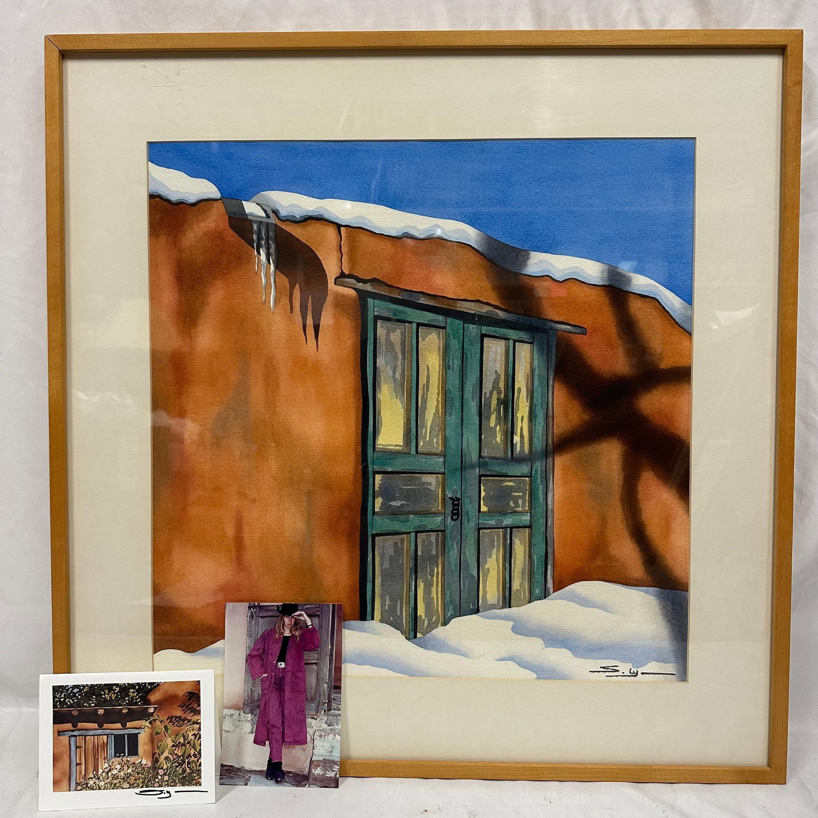 Signed Watercolor Painting by Shirley Lynn with Personalized Photo Print: Original watercolor painting by artist Shirley Lynn, depicting an adobe building with green doors and snow under a bright blue sky. Signed “S. Lynn” lower right. Includes two pieces of acc