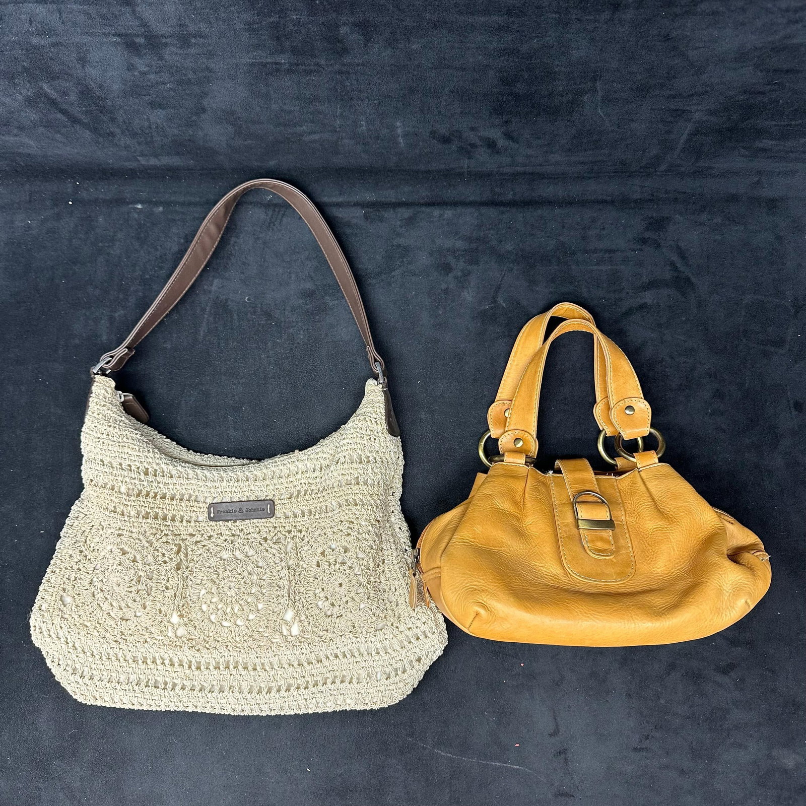 Frankie and Johnnie Crochet Shoulder Bag Plus North Style Leather Handbag 2 Bag Lot: A lot of two women’s handbags. Includes: Frankie & Johnnie crochet shoulder bag in cream with brown strap, zip closure, and interior pockets. Light wear, some discoloration, and stains to th