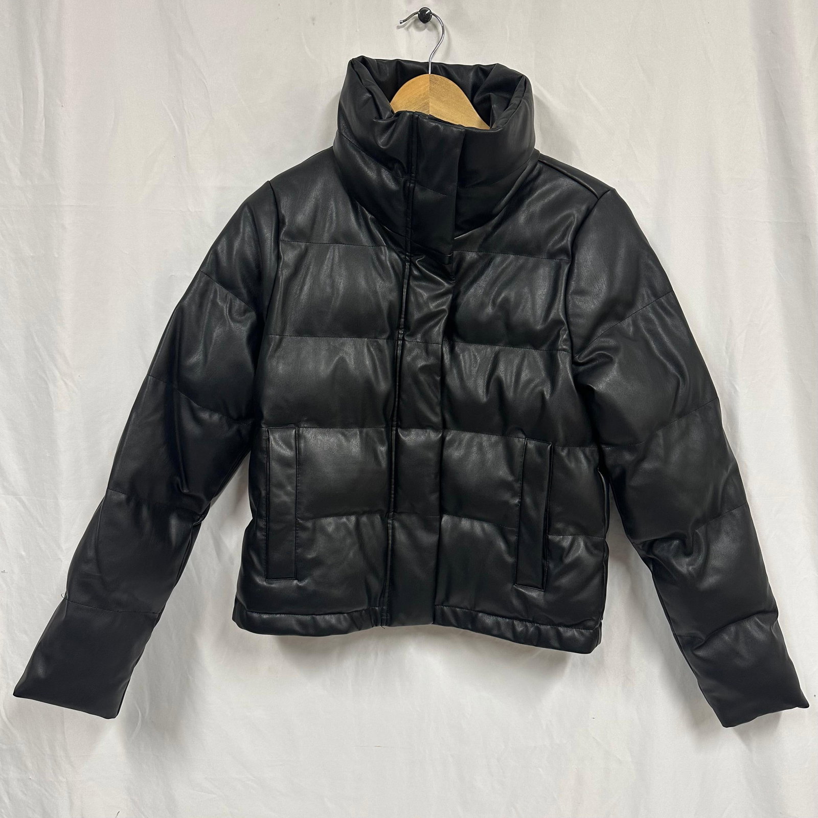 Abercrombie and Fitch Black Faux Leather Puffer Jacket Women Size Small: Women’s black puffer jacket by Abercrombie and Fitch featuring a faux leather exterior. Designed with a high stand collar, full front zip closure with snap placket, and two front hand pockets. Q