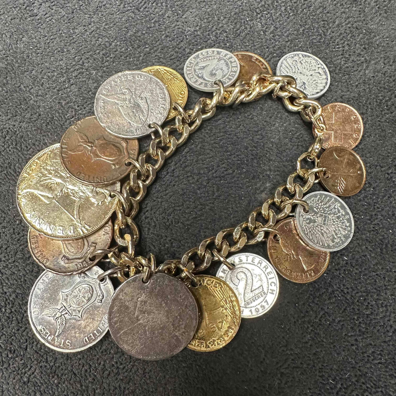 Foreign World Coin Charm Bracelet Mixed International Coins: Unique vintage charm bracelet featuring an assortment of world coins from different countries and eras, including British, Austrian, American, and others. Coins range in size, design, and patina,