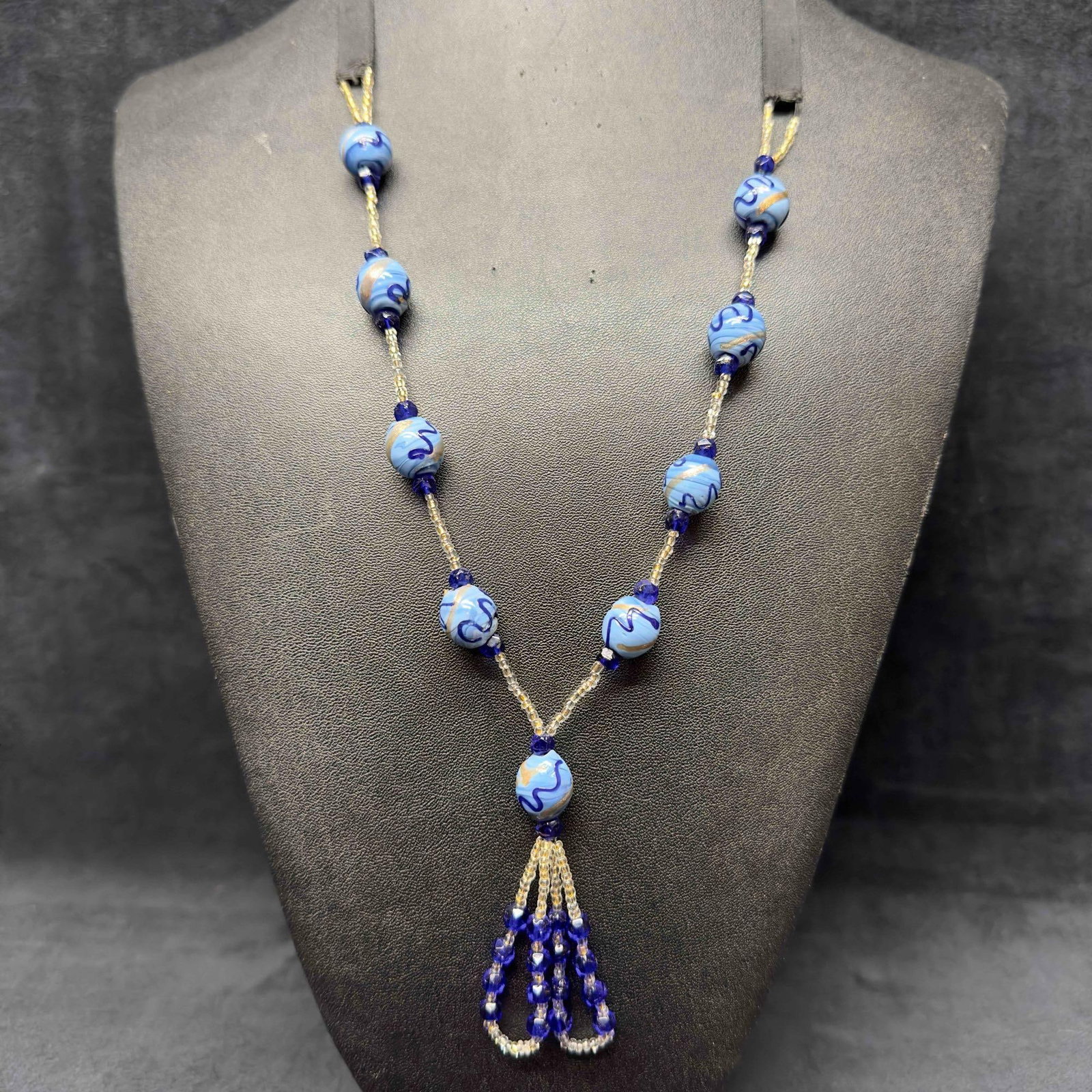 Venetian Murano Art Glass Lamp Work Dark and Light Blue Beaded Silver Accent Necklace E52: Venetian Murano Art Glass Lamp Work Dark and Light Blue Beaded Silver Accent Necklace E52. Necklace with dark and light blue colored glass beads with beautiful designs on each. The necklace features a