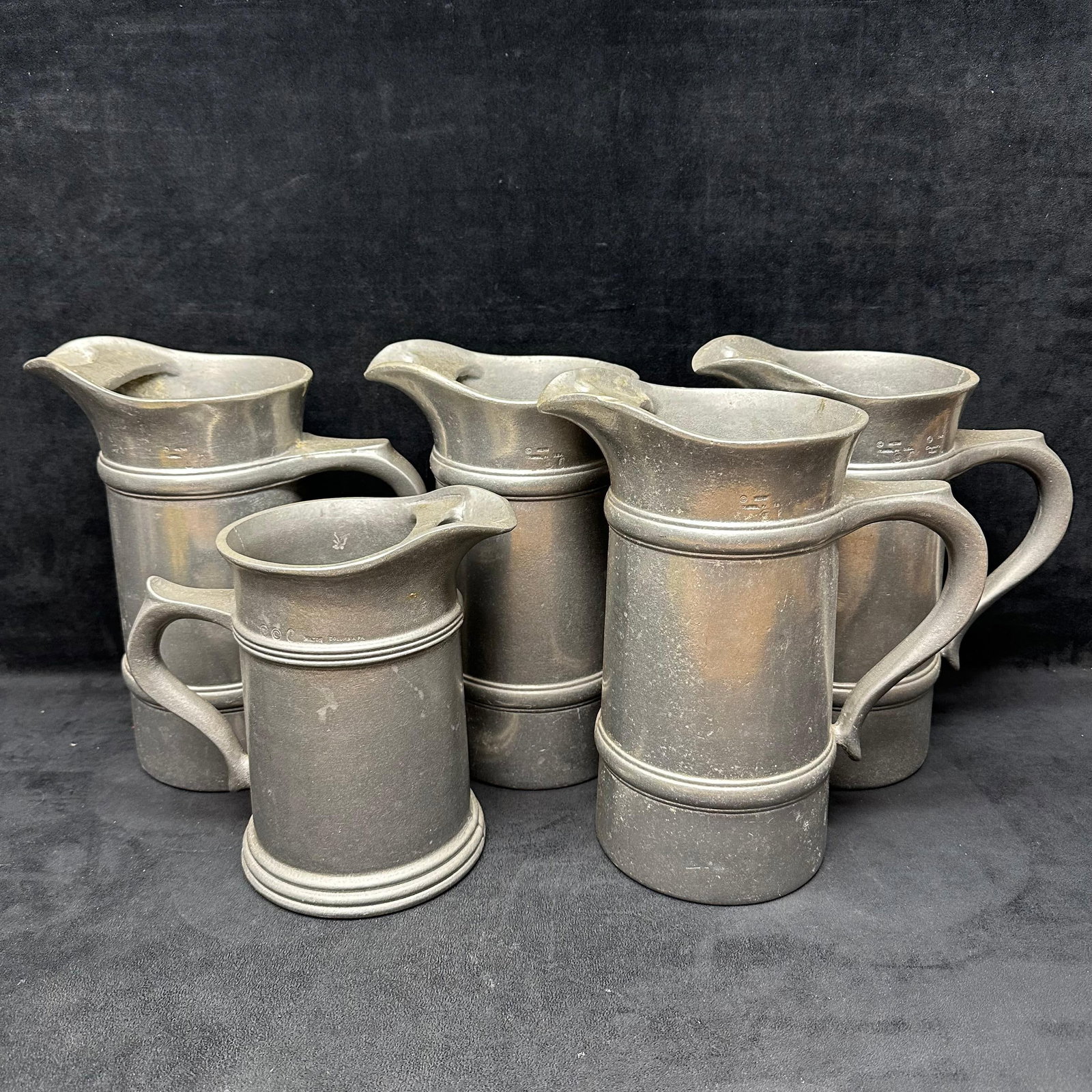 Set of Five Columbia Aluminum-based Alloy Tankards Pitcher Set Country Ware Collection: Set of five heavy aluminum-based alloy tankards by Wilton-Columbia, Pennsylvania, part of their Country Ware Collection, dated 1978. Each pitcher features a classic 18th-century-inspired design with d