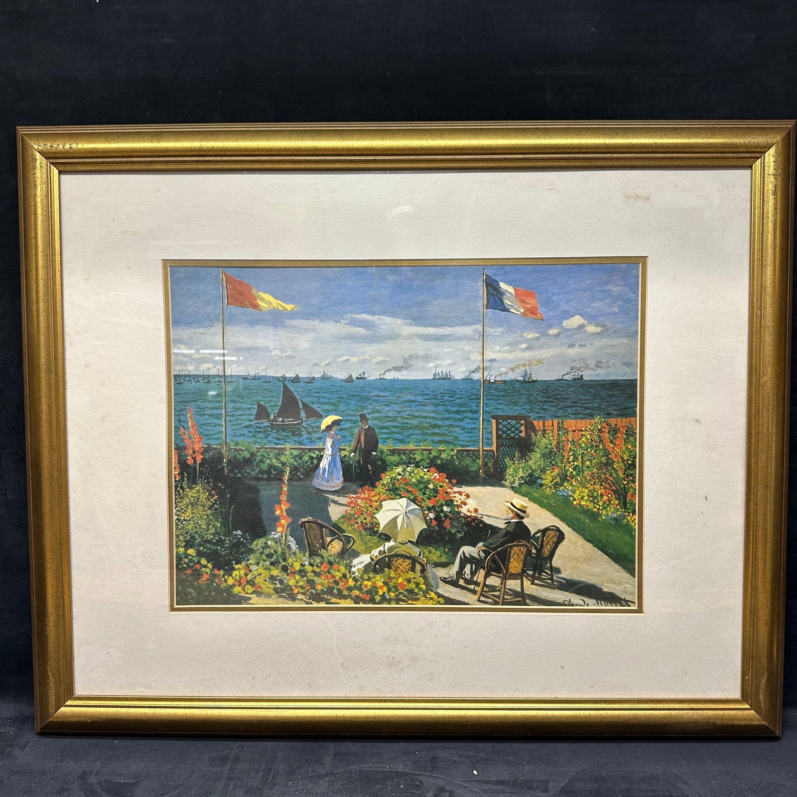 Framed Claude Monet Garden At Sainte Adresse Art Print R235: Framed art print after Claude Monet depicting “Garden At Sainte Adresse”, a coastal garden scene with figures and sailboats. Print signed Claude Monet within plate lower right. Presented u