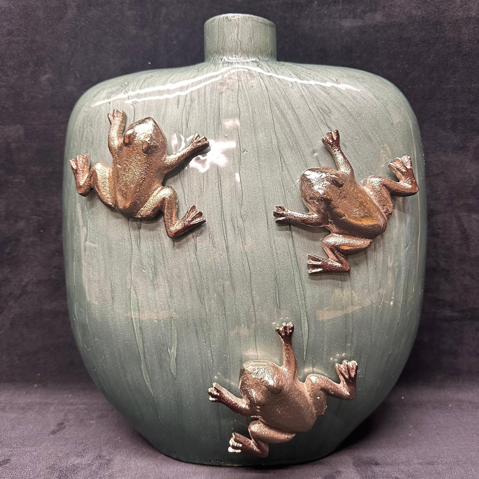 Green Art Glass Vase with Applied Frog Motif Ornaments: Decorative green art glass vase featuring three applied metallic frog figures climbing the exterior. The vase has a softly rounded rectangular form with a narrow cylindrical opening at the top and a s