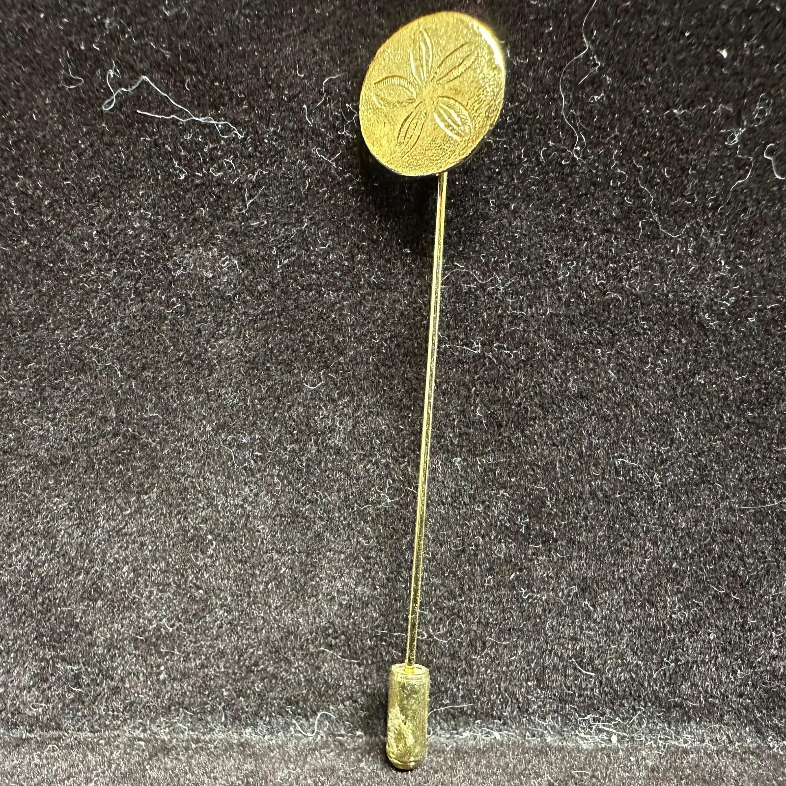 Gold Crown Trifari Stick Pin Nautical Sand Dollar: Gold-tone crown Trifari stick pin featuring a nautical sand dollar theme. This item is in good pre-owned, previously used/displayed condition with noticeable light wear and surface scratches.