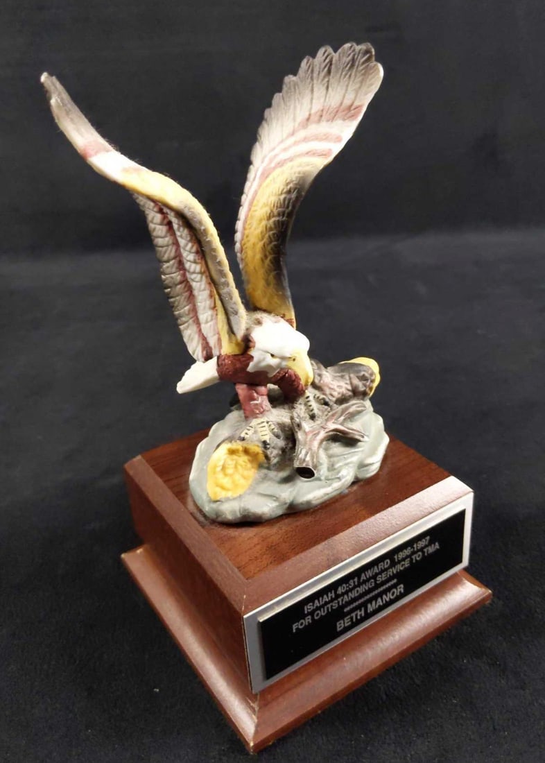 Small Eagle On Wood Base Award Mantlepiece: This was an Isiah Award For Outstanding Service. Removable plaque is attached to a wooden base with a resin eagle with his wings spread. Award is approx 4" x 4" x 7". Eagle has a small scratch on