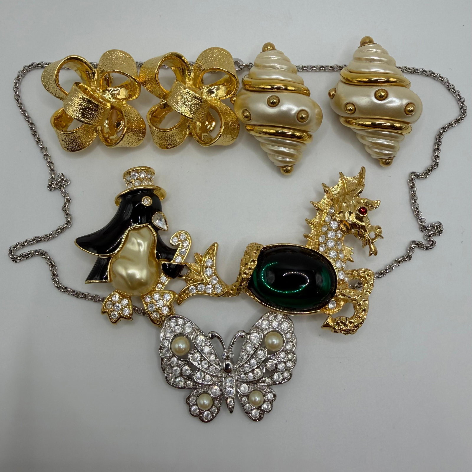 Kenneth Jay Lane Penguin Sea Horse Sea Shell Clip Earrings Butterfly Necklace KJL Set: Collection of signed Kenneth Jay Lane (KJL) designer costume jewelry featuring whimsical figural and statement designs. Lot includes brooches, earrings, and a necklace. All pieces are signed KJL. Seve
