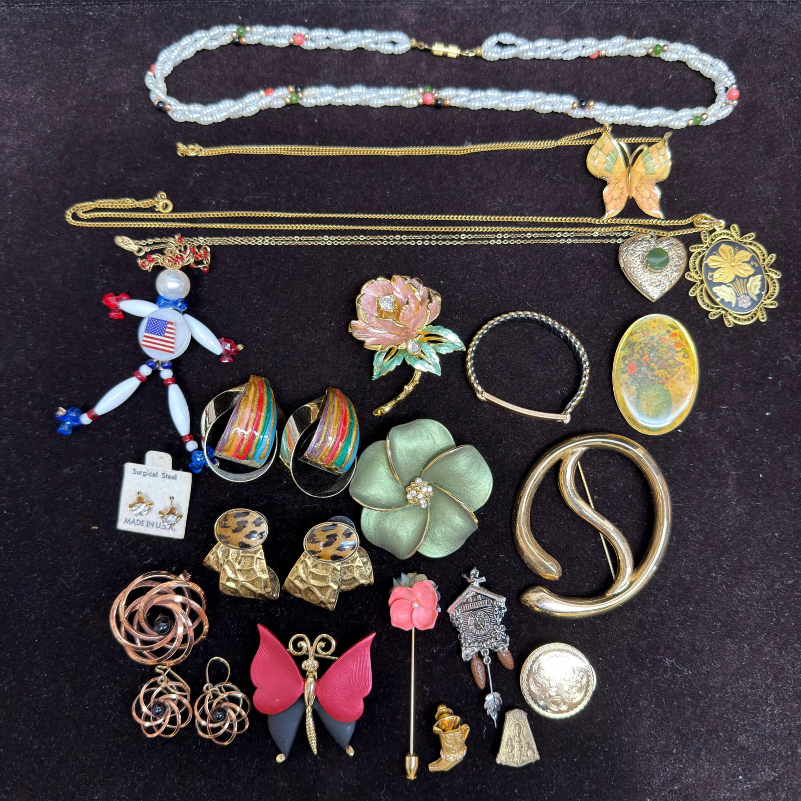 Vintage Costume Jewelry Group Including Floral Butterfly Locket Necklace Pieces: Assorted vintage costume jewelry group featuring necklaces, brooches, earrings, bracelets, lockets, and pins. Includes a blue beaded necklace, butterfly pendant necklace, floral enamel brooch, large