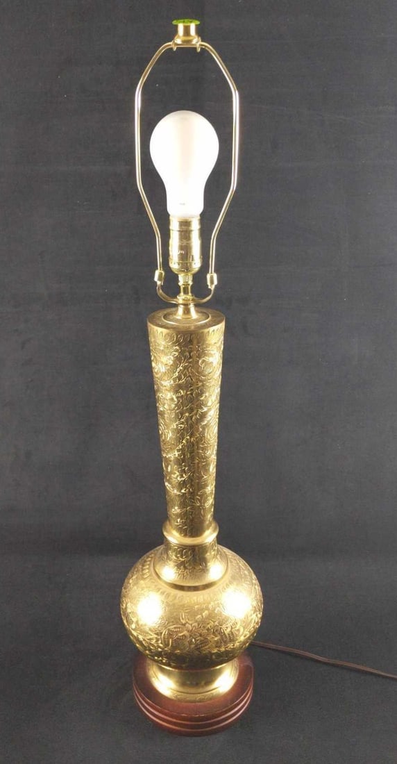 Middle Eastern Ornate Leaf Carved Brass Table Lamp B: Middle Eastern Ornate Leaf Carved Brass Table Lamp. The lamp base is covered in a lovely detailed floral pattern. This is a three-way lamp. The maker and date of creation are unknown. Lamp is approx 7