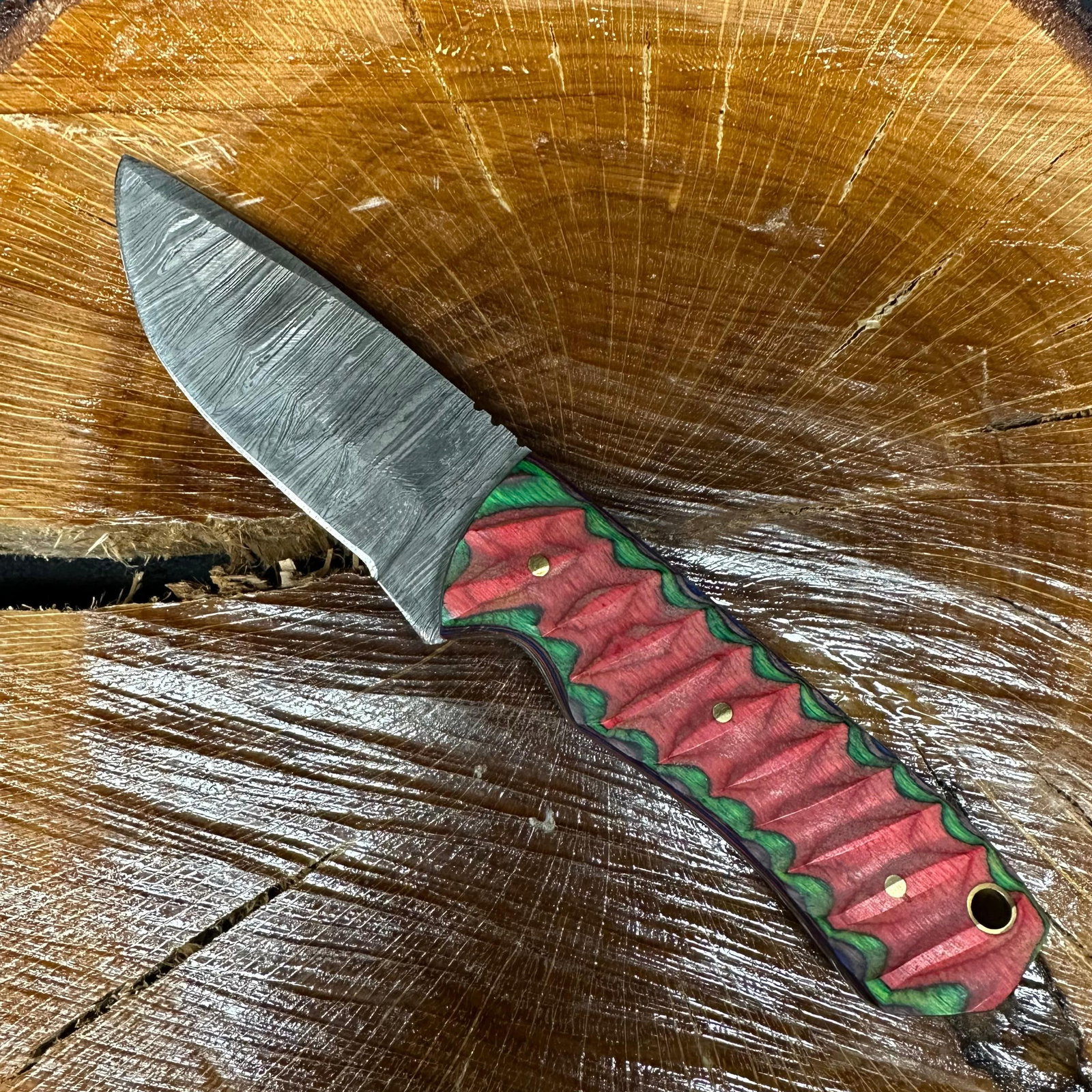 MHS Cutlery Fixed Steel Patterned Blade Knife P74 Red Green Purple: Fixed blade knife by MHS Cutlery featuring a patterned steel blade with a straight profile. The textured, carved handle is constructed with multi-tone stabilized epoxy resin/wood material in red, gree
