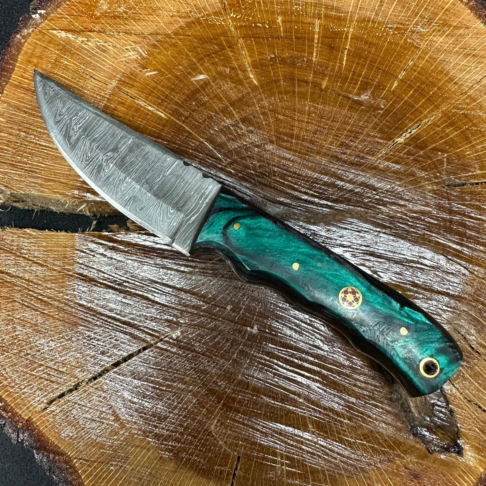 MHS Cutlery Fixed Layered Patterned Blade Knife P79: Fixed blade knife by MHS Cutlery featuring a layered patterned steel blade and decorative spine work. The handle has a contoured, black, green, and red wood/epoxy resin-style grip with metal mosaic pi