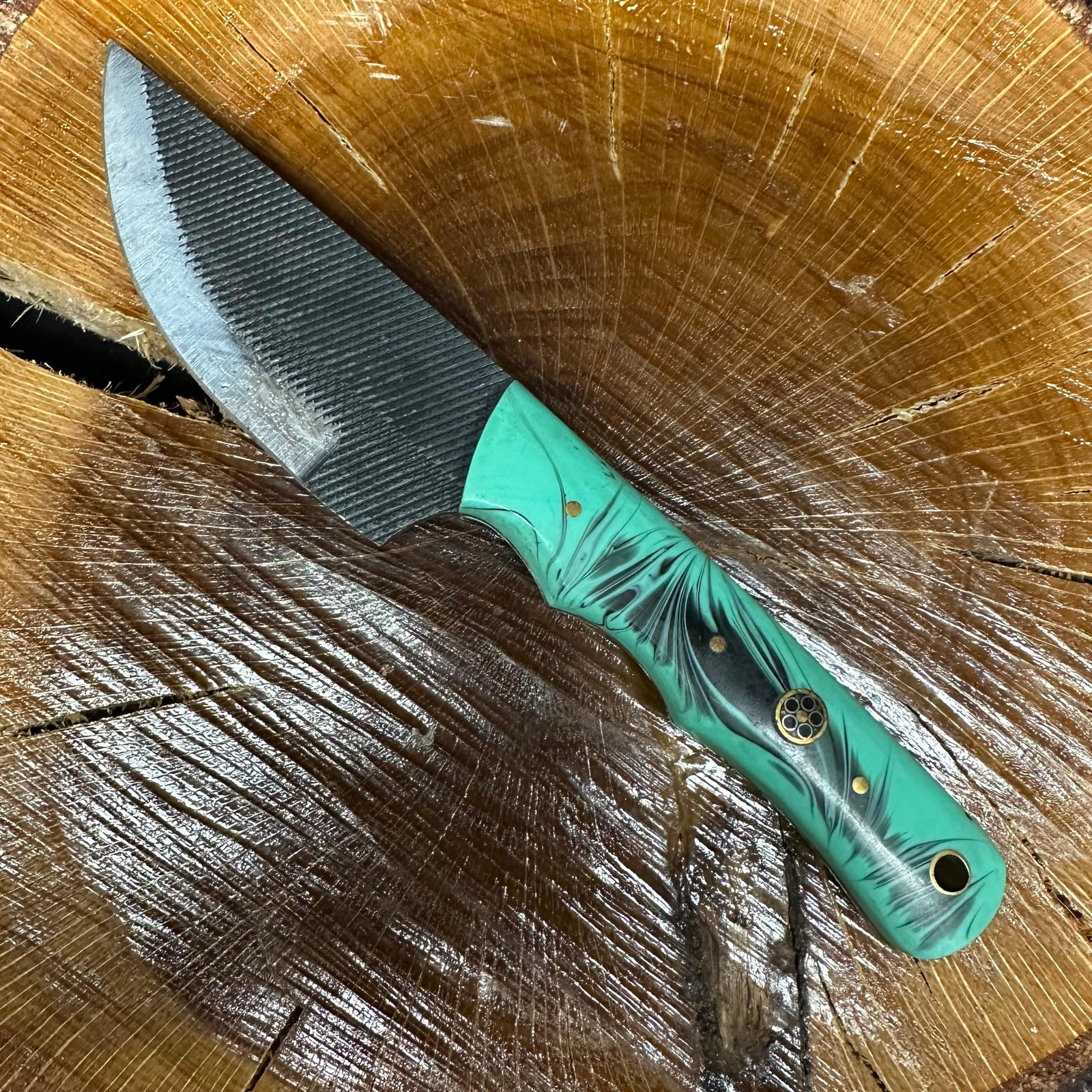 Black and Aqua MHS Cutlery Fixed Steel Blade Small Curved Knife: Fixed blade knife by MHS Cutlery featuring a patterned textured steel blade with a curved profile. The handle is constructed with multi-tone stabilized resin/wood material in blue, green, aqua tones, 