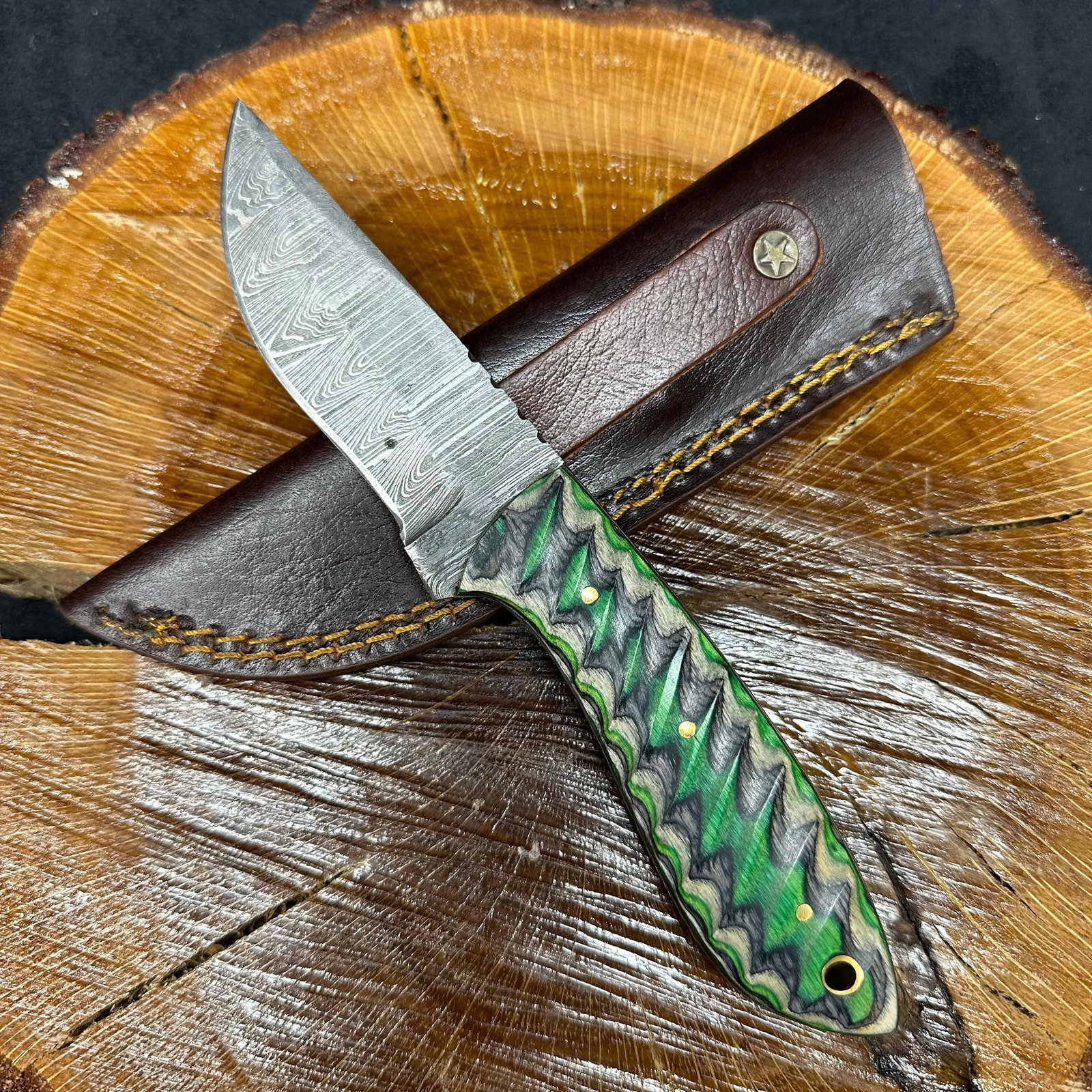 MHS Cutlery Fixed Blade Curved Handle Knife with Sheath Q7: Fixed blade knife by MHS Cutlery featuring a layered patterned steel blade and decorative spine work. The handle has a contoured, multi-colored wood/epoxy resin-style grip with metal mosaic pin accent