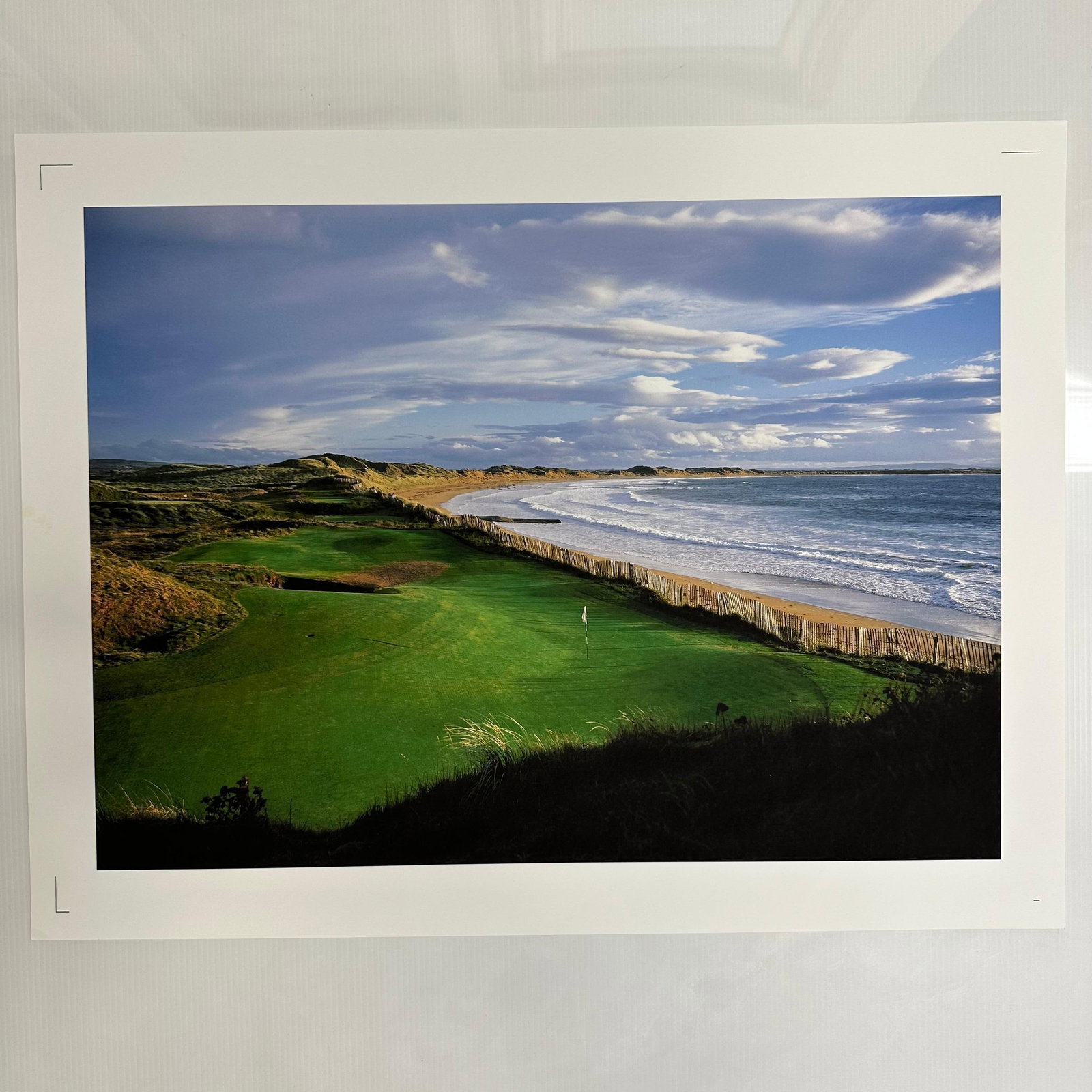 Coastal Sweeping Ocean Golf Course Landscape Photograph Print Oceanfront Fairway: Color photograph print capturing a sweeping coastal golf course view, with the fairway running parallel to the ocean and framed by rolling dunes under a dynamic cloud-filled sky. The image highlights 