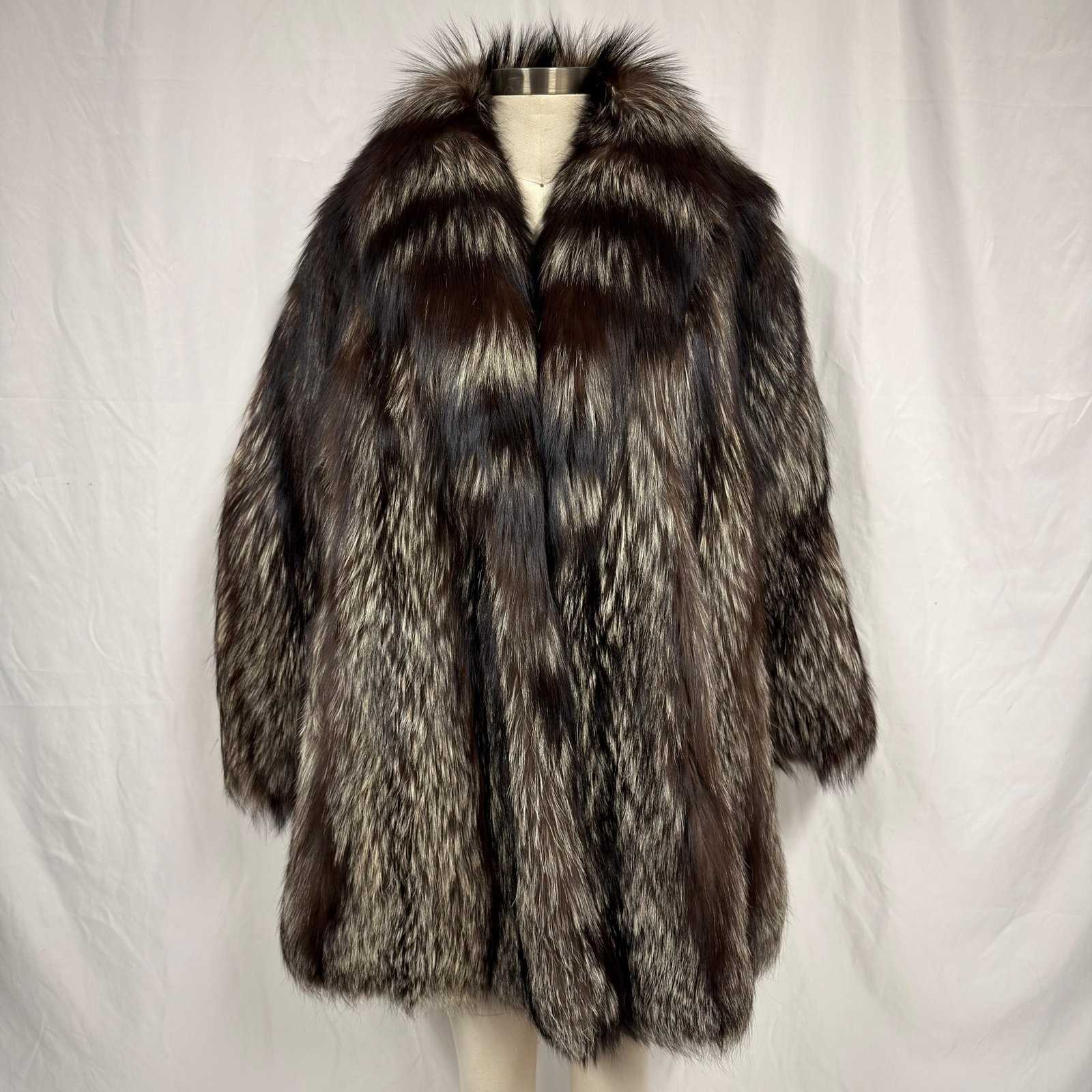Gray and Black Fox Fur Coat Mid Length FC9I: The fur coat appears to be crafted from genuine natural fur and retains excellent volume and softness. Overall, the Fur Coat is in good pre-owned condition, with some light wear and minor separation