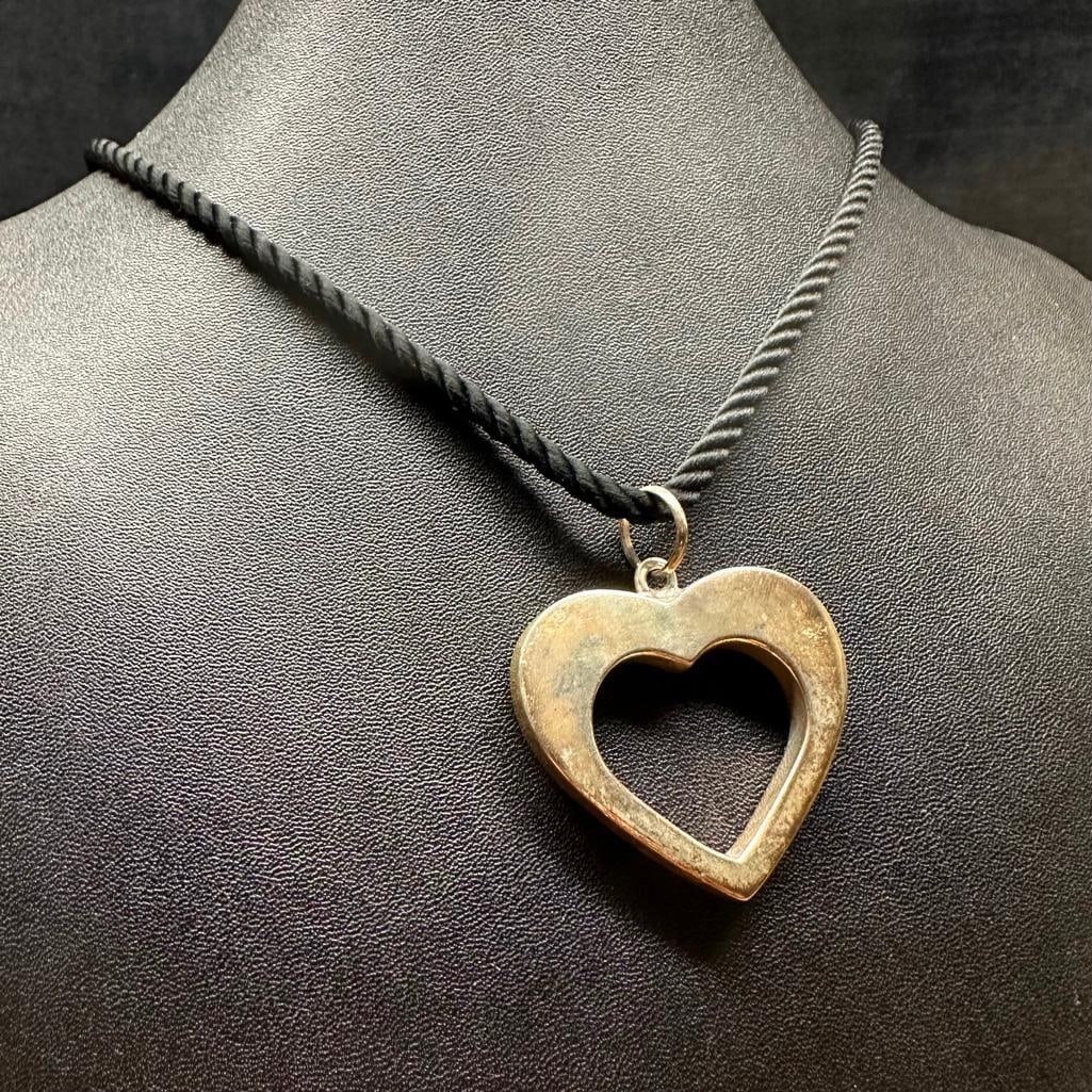 Sterling Silver Heart Pendant on String Necklace: This piece of jewelry has been tested and researched prior to listing. Please view all our pictures they are part of our description. DETAILS: Metal - Sterling Silver Color - Silver Stones - none Hall