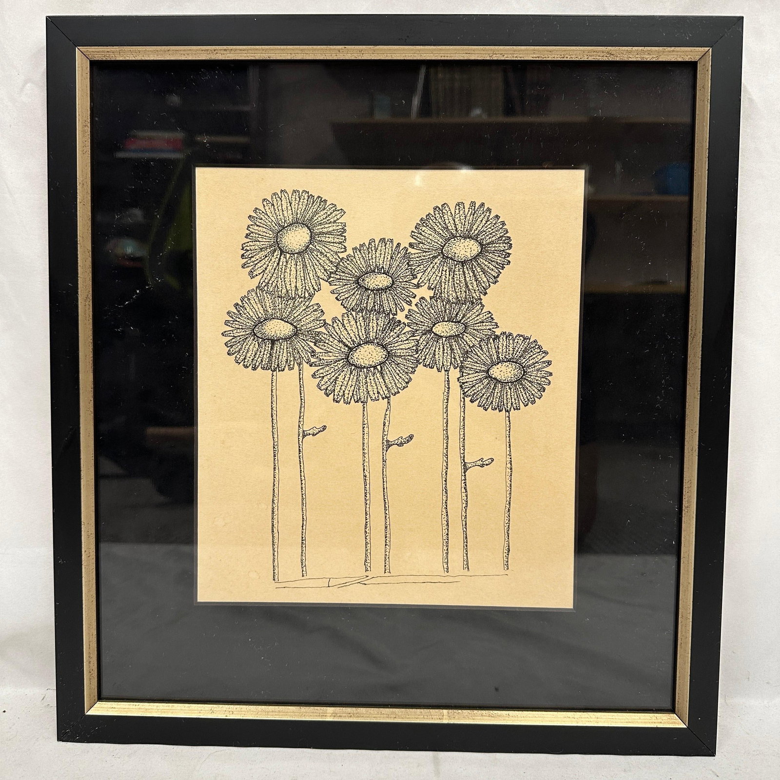Framed Minimalist Floral Line Art Drawing Print: Framed minimalist floral line art drawing or print depicting stylized daisy flowers in black ink on toned paper. Housed under glass in a black and gilt tone frame. Light age toning and minor wear to t